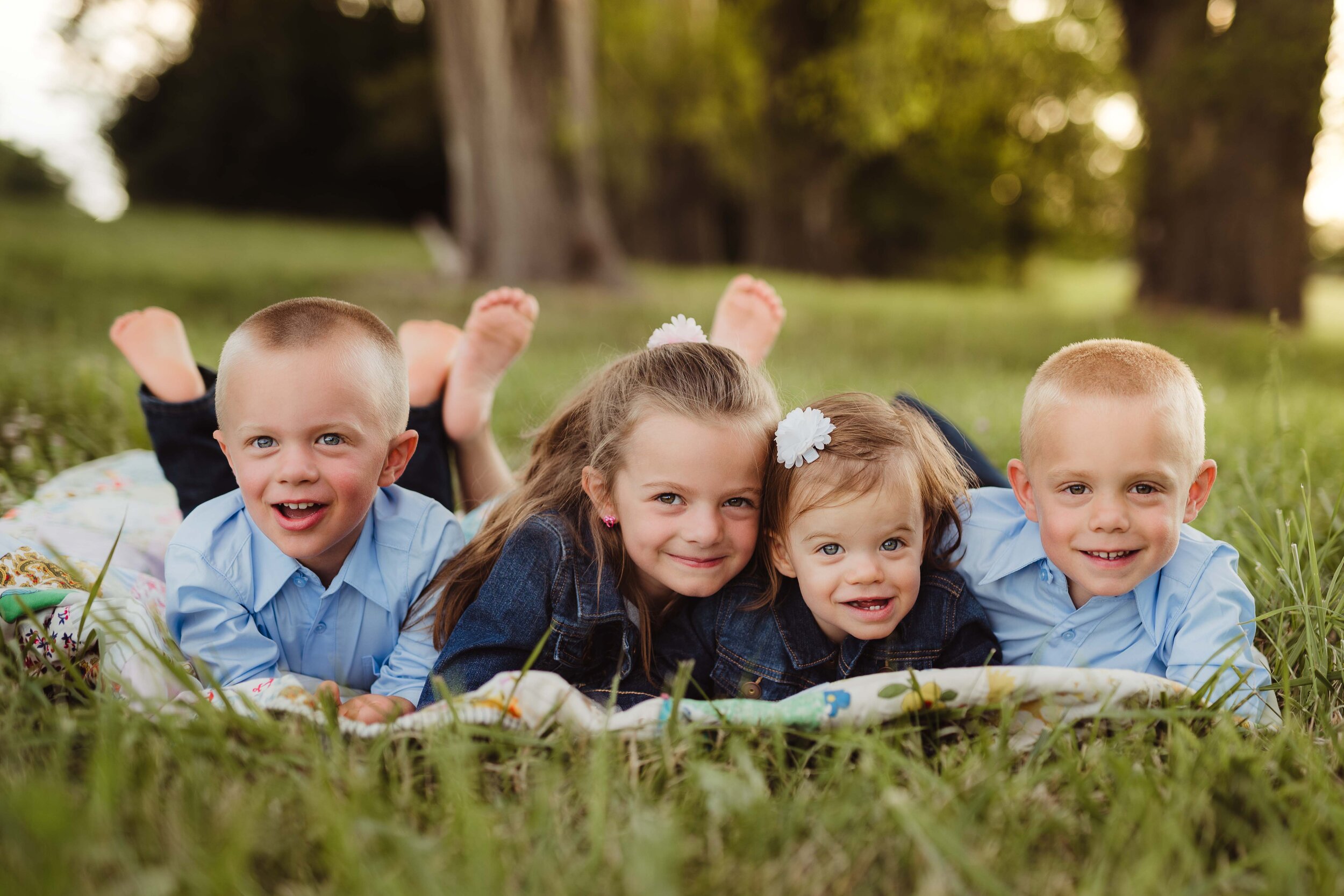 four little kids smiling for their summer family photo session in Lafayette, Indiana with Kelly McPhail Photography