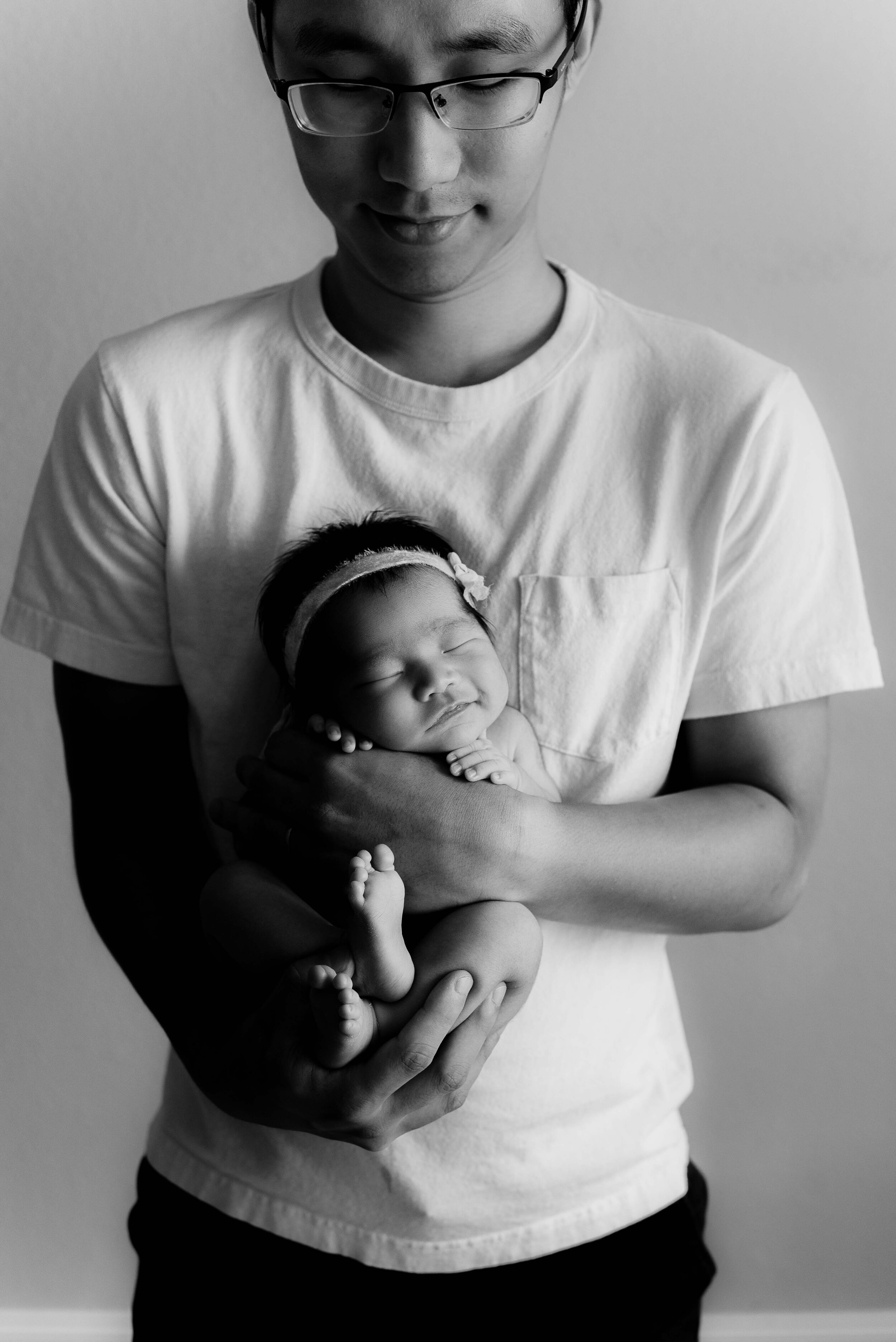 dad holding newborn baby in in-home newborn photo session in West Lafayette, Indiana