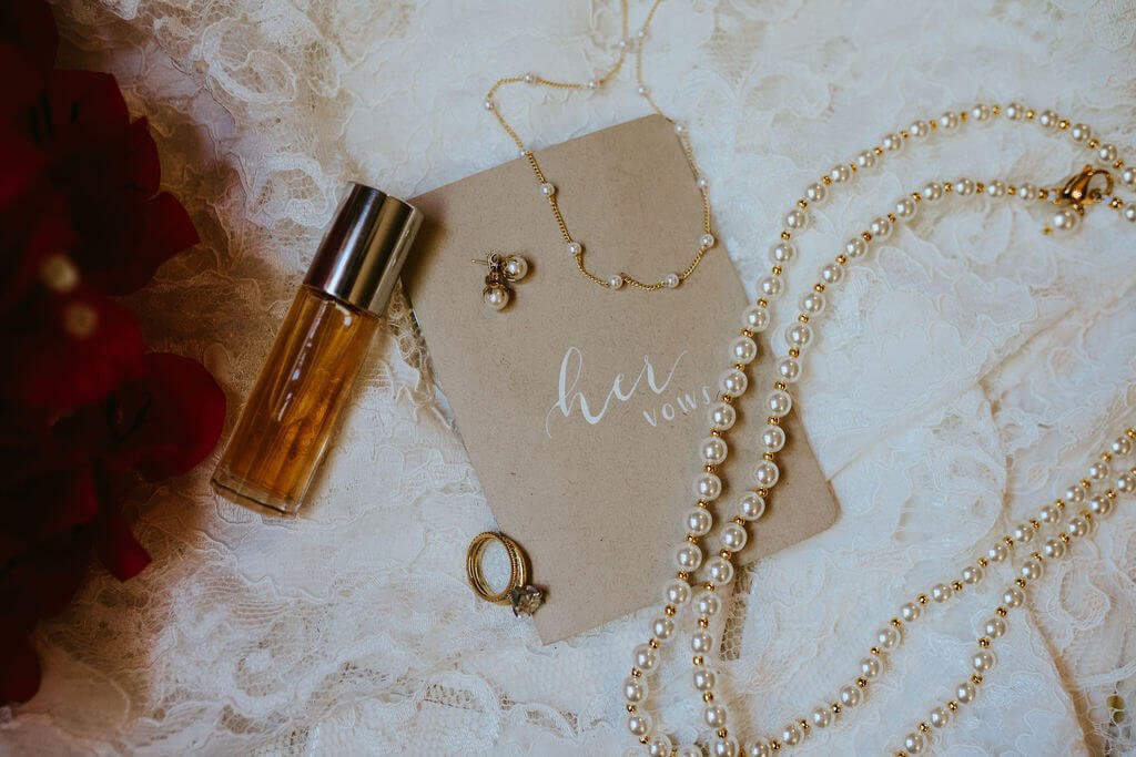 Flat-lay of wedding rings, necklace, and invitations for Arizona desert wedding