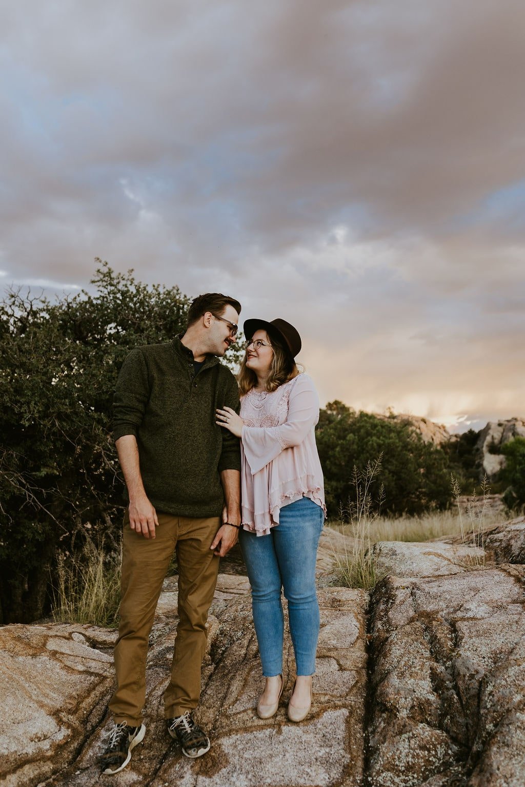 Couple standing on a desert rock during Arizona engagement photos