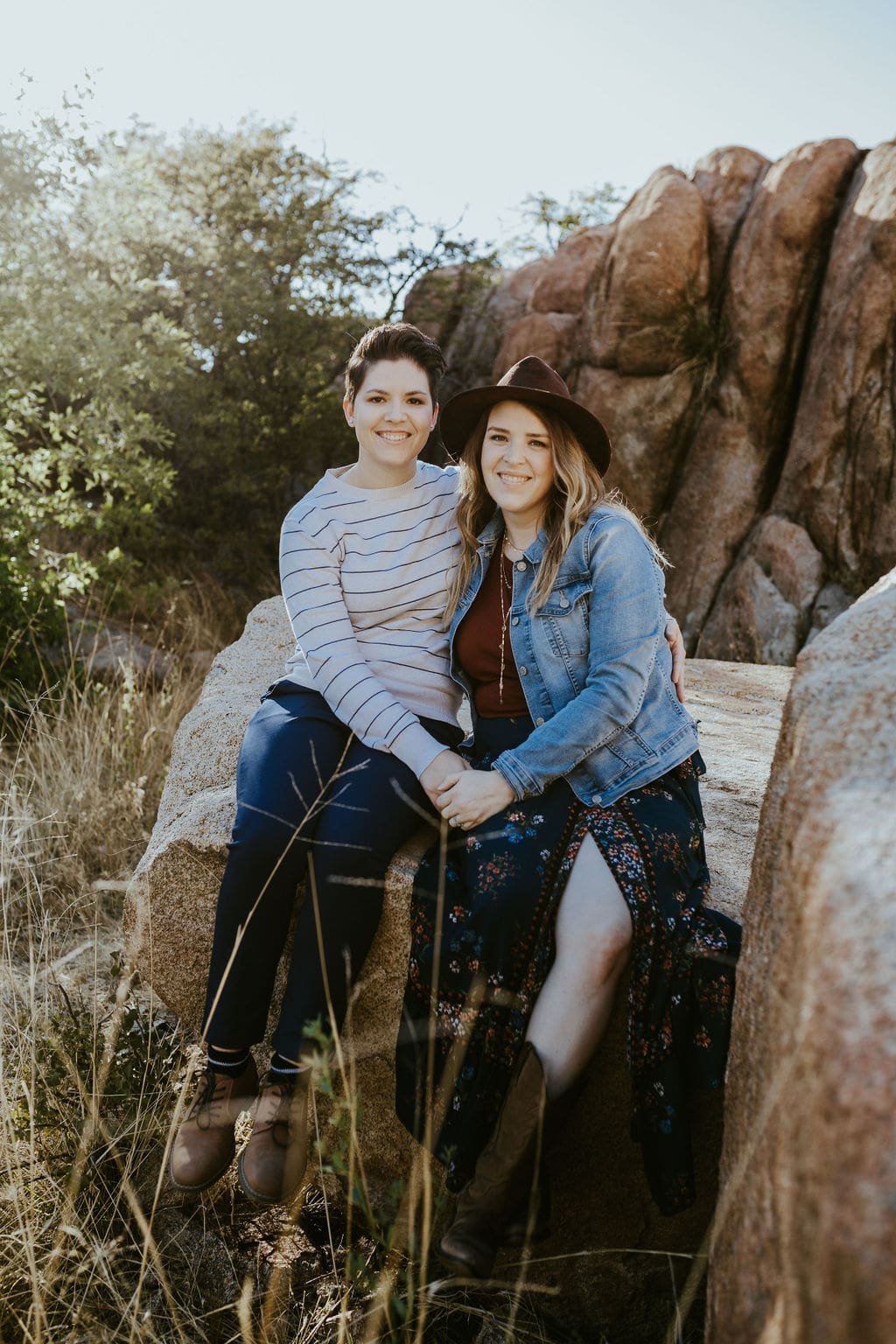 Couple sitting on the desert rocks during Arizona engagement photos