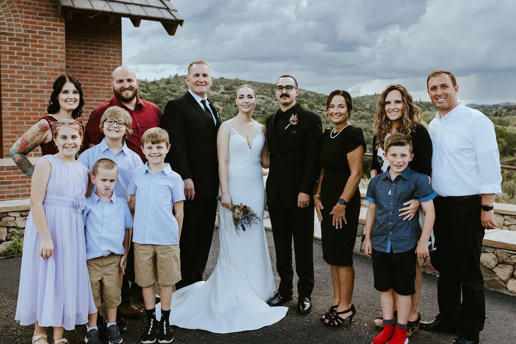 Bride and groom with family members at intimate woodland wedding