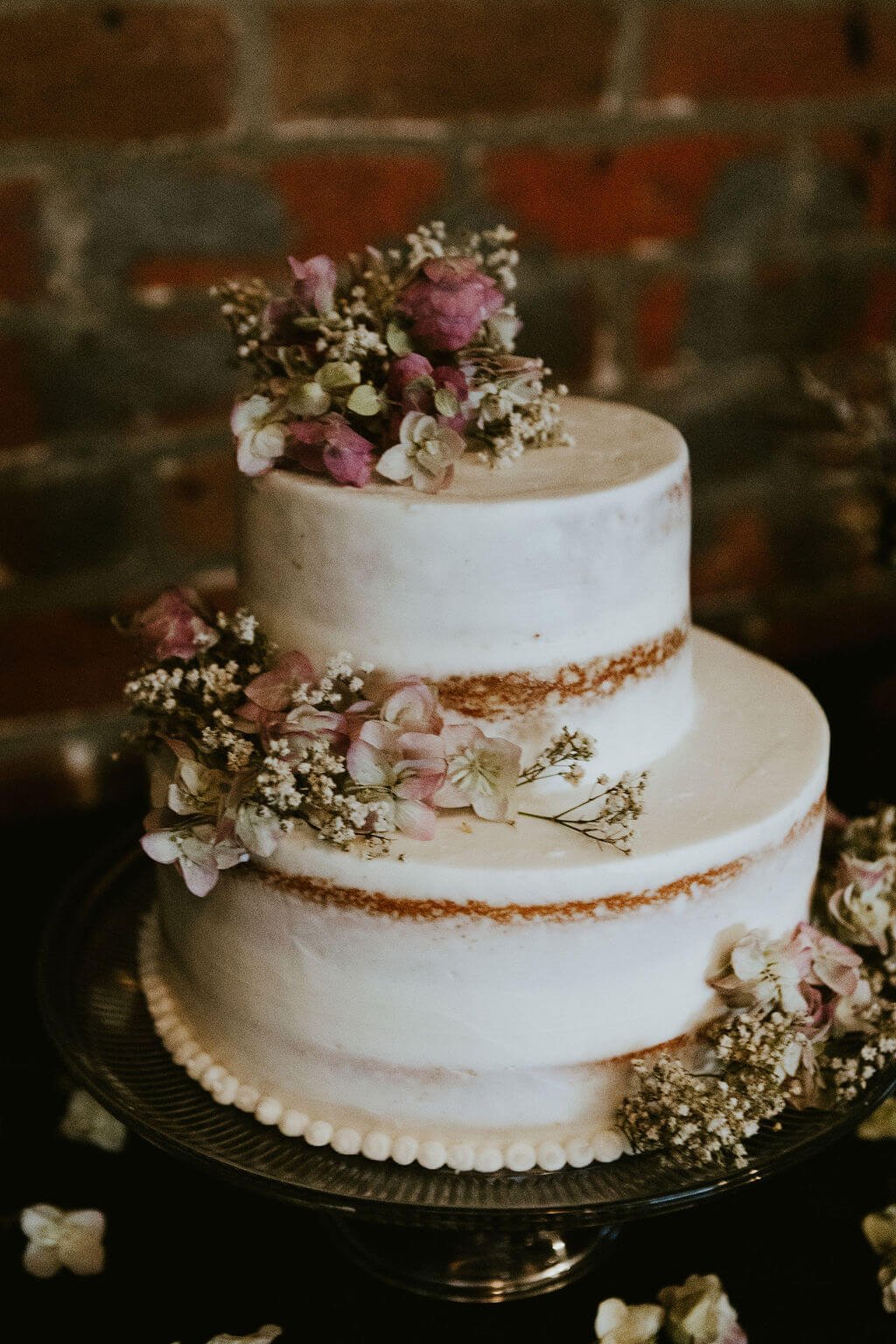 White wedding cake with floral arrangement on top