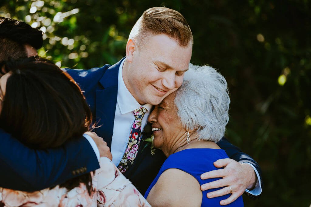 Groom hugging his husband's mother at intimate Southern California wedding