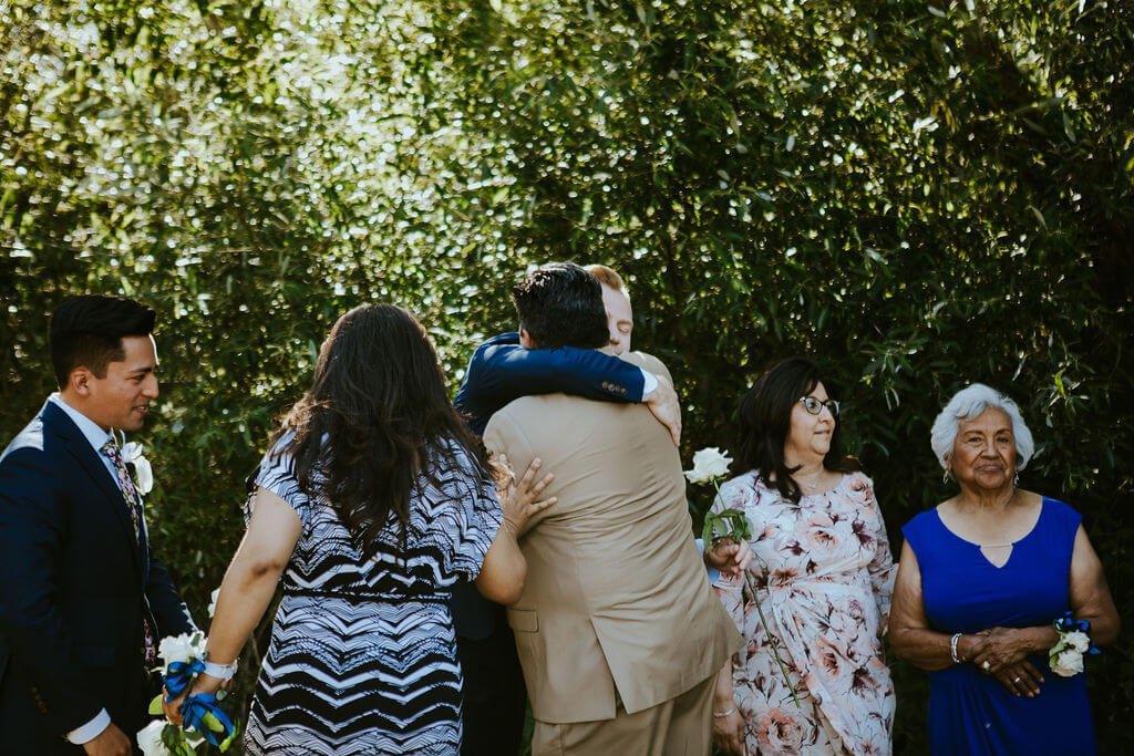 Grooms hug their families after wedding ceremony for Southern California wedding