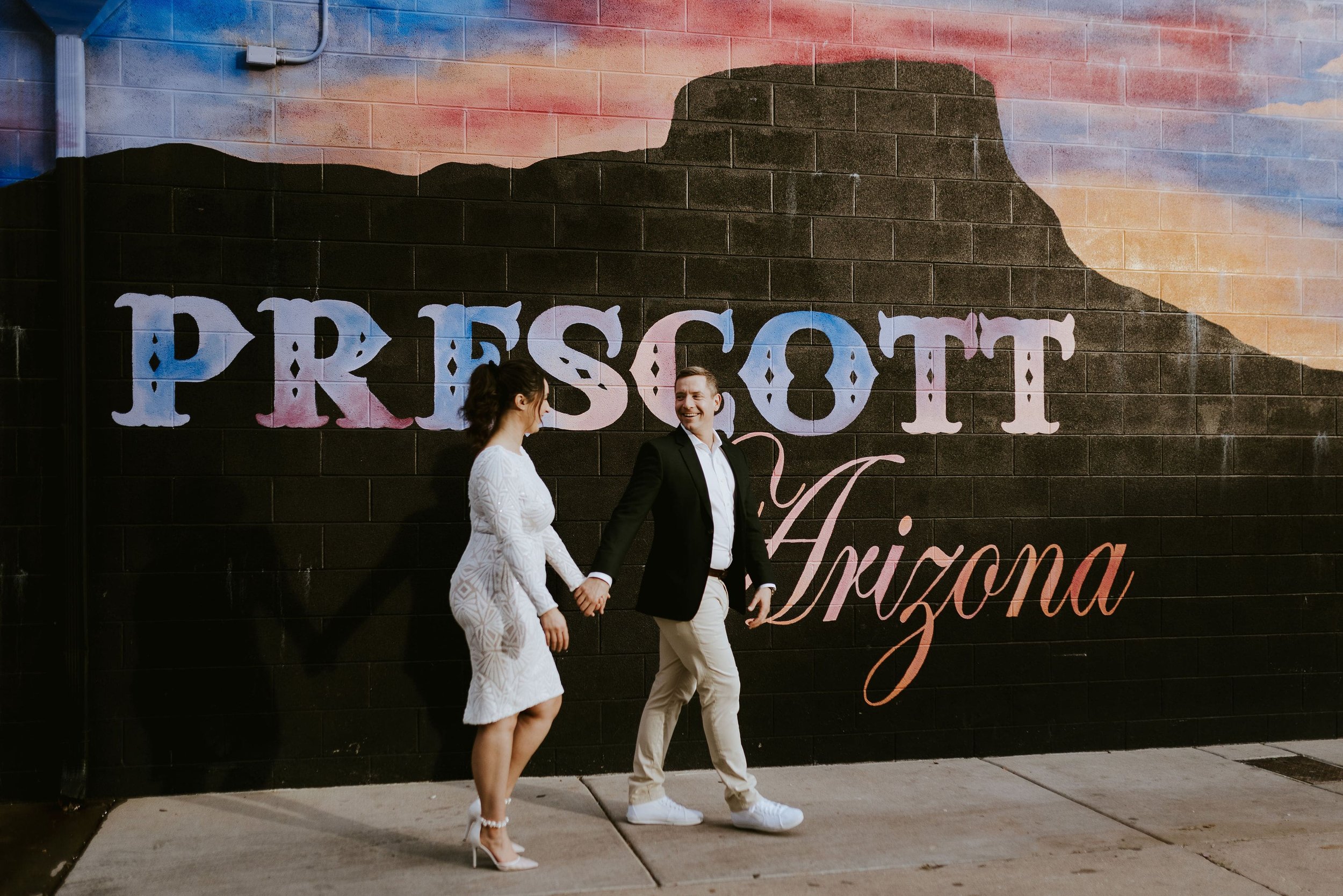 Bride and groom hold hands during elopement photos in downtown Prescott, Arizona