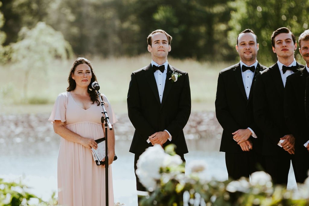 Groom waits at the end of the aisle during classic wedding ceremony