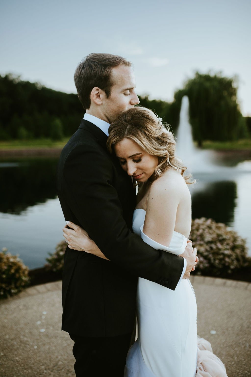 Bride and groom hug during wedding portraits at Orchard Ridge Farms wedding