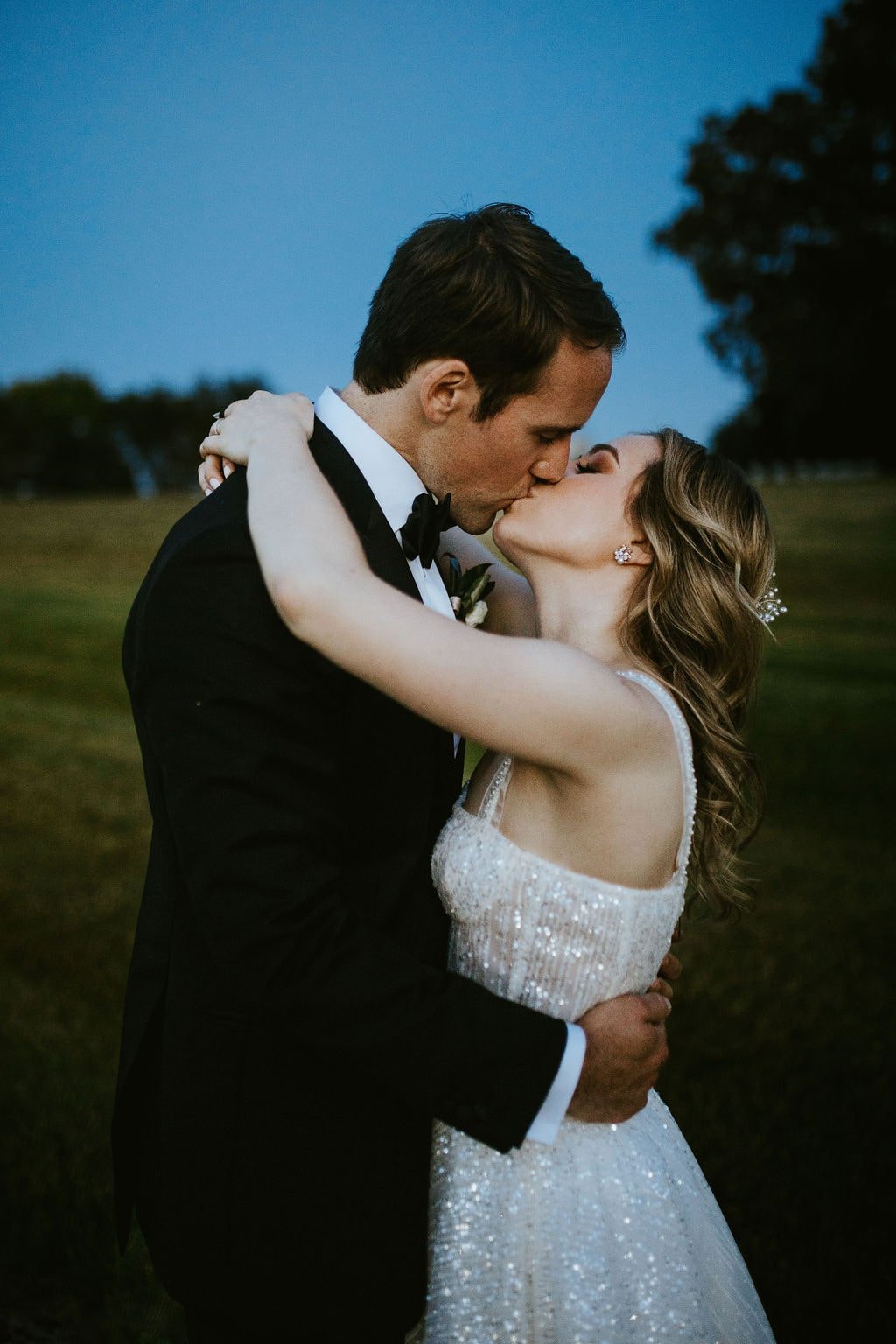 Bride and groom kiss during blue hour photos at Orchard Ridge Farms classic wedding