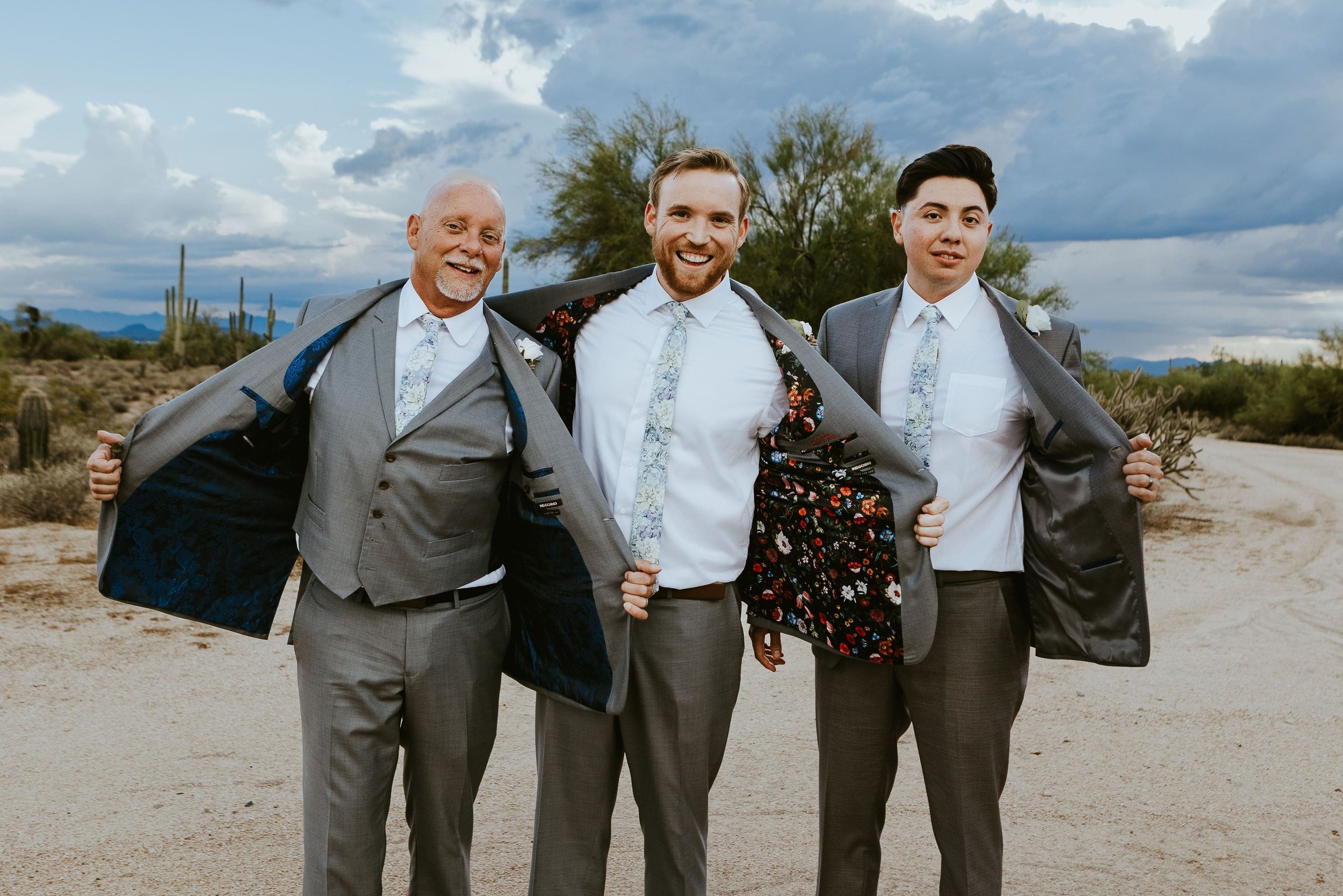 Groom and groomsmen in gray suits with white shirts and blue floral ties