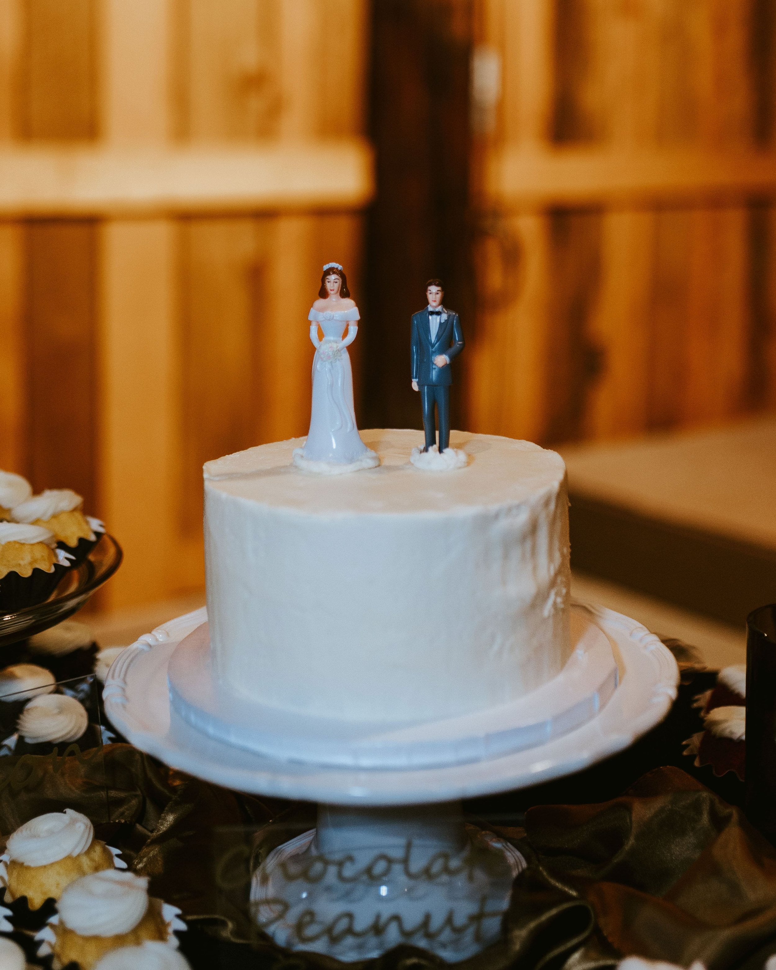 White frosted wedding cake with bride and groom cake toppers