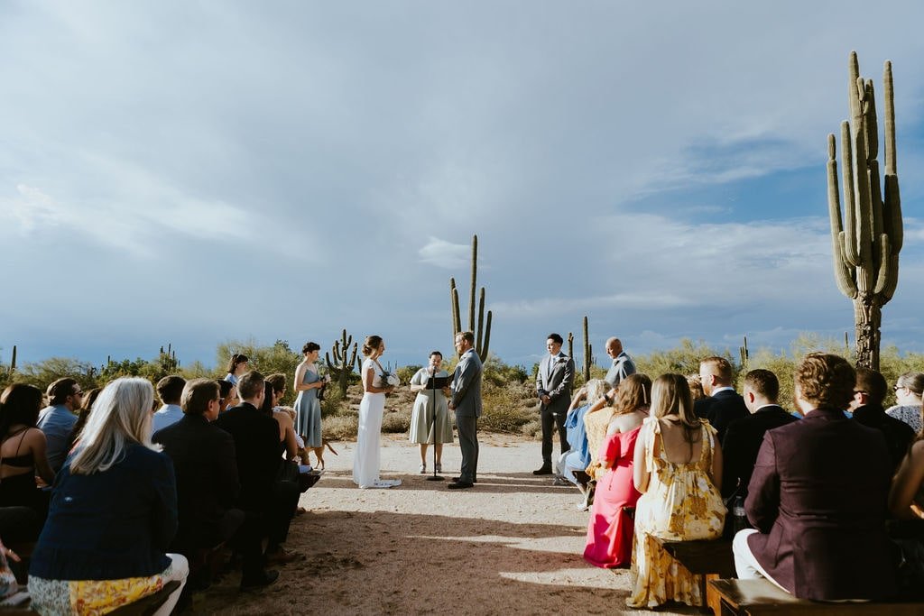 Bride and groom hold hands at the altar during their fall wedding ceremony in Arizona