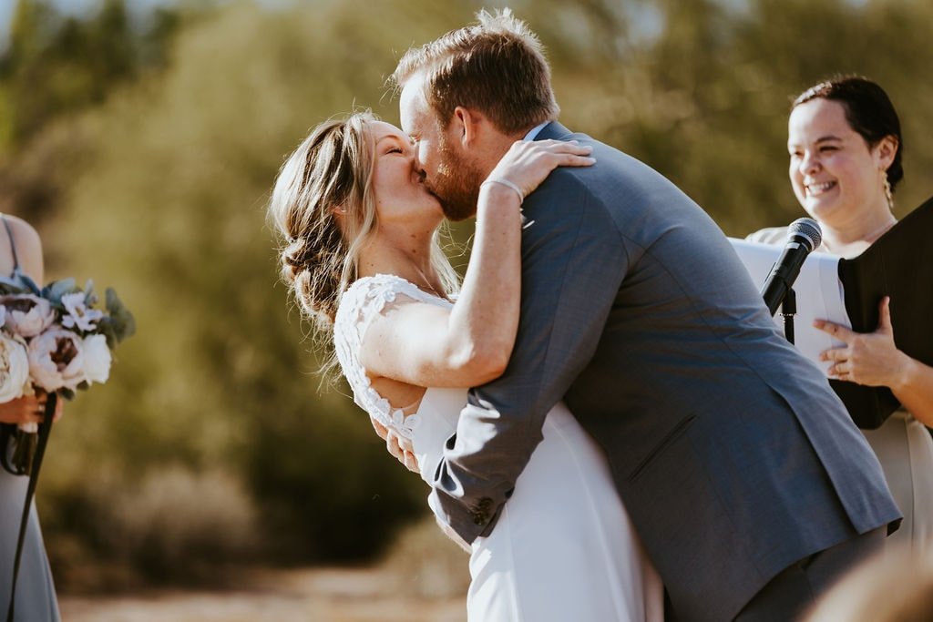 Bride and groom kiss during their desert foothills wedding ceremony in Arizona