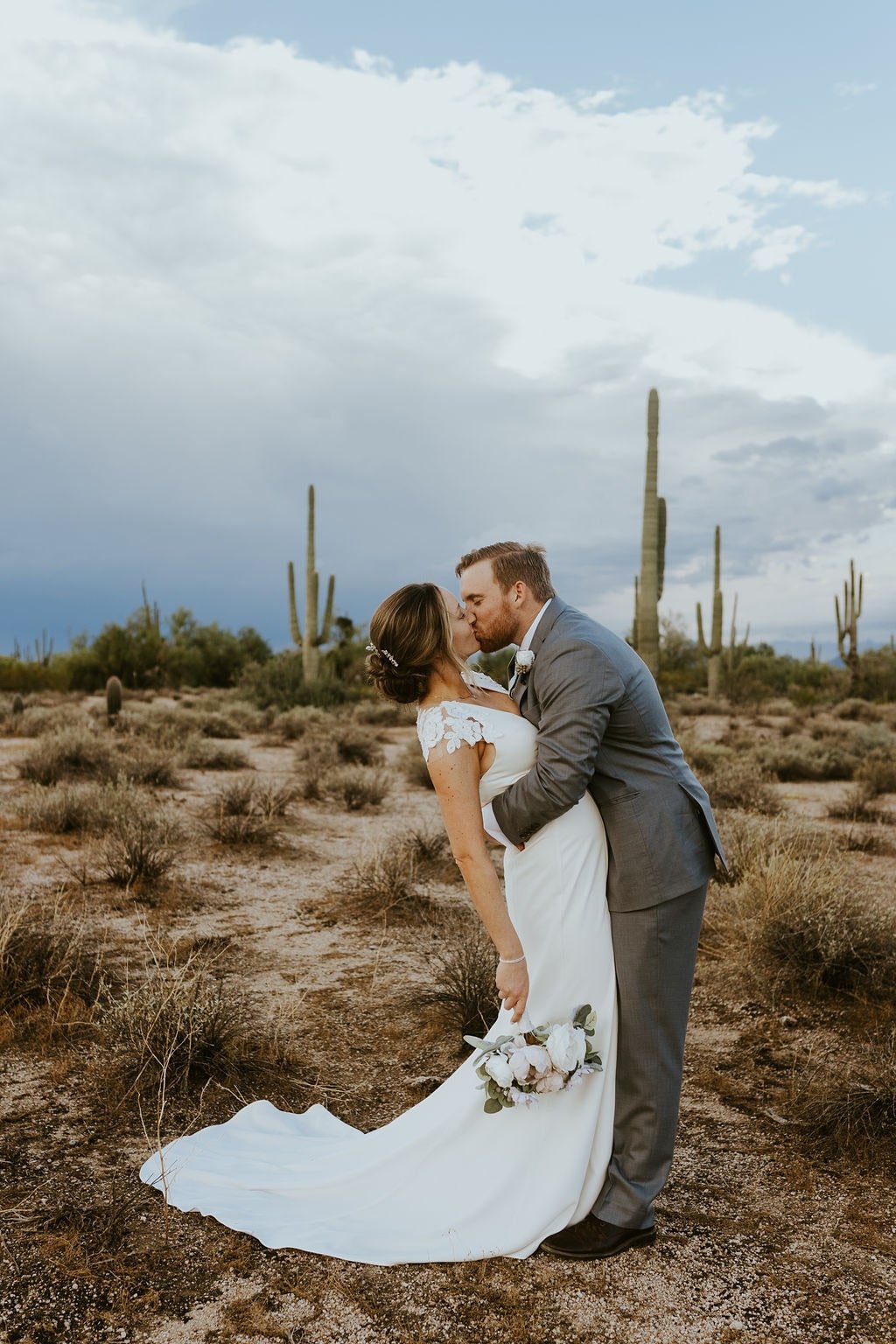 Bride and groom kiss during desert foothills wedding in Arizona