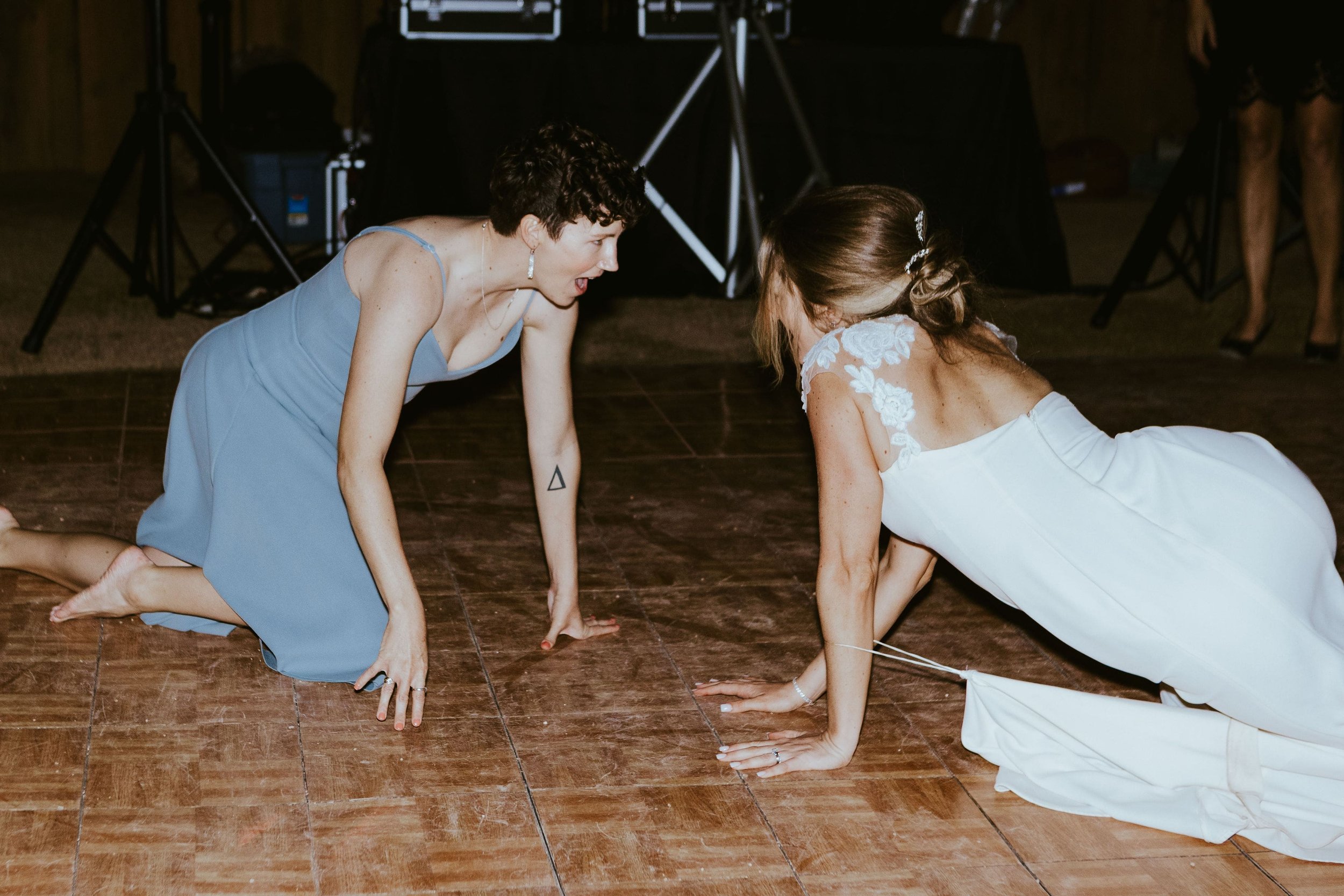 Bride and sister crawling on the dance floor at her fall wedding in Arizona