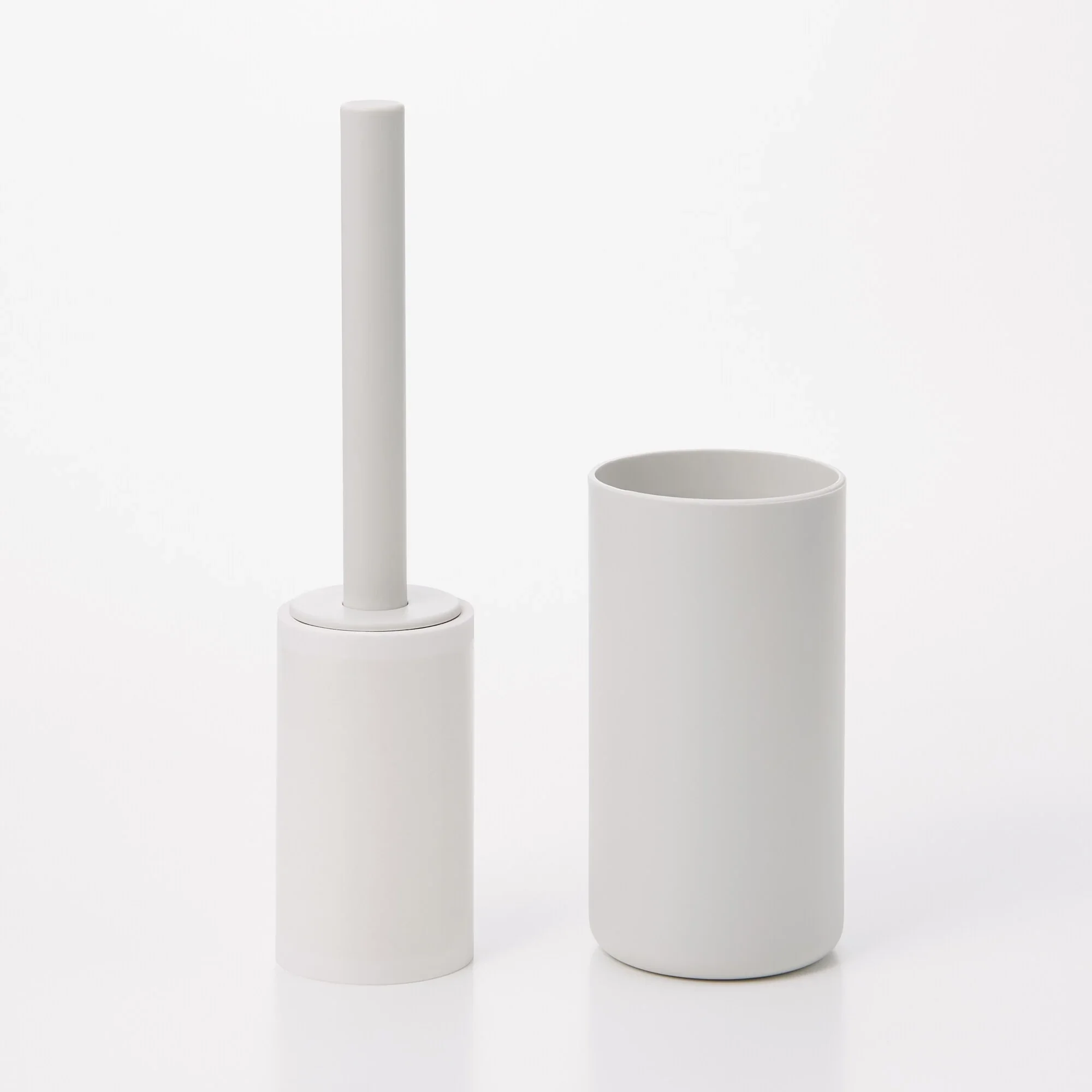 Minimalist white cylindrical objects of different heights on a white background.