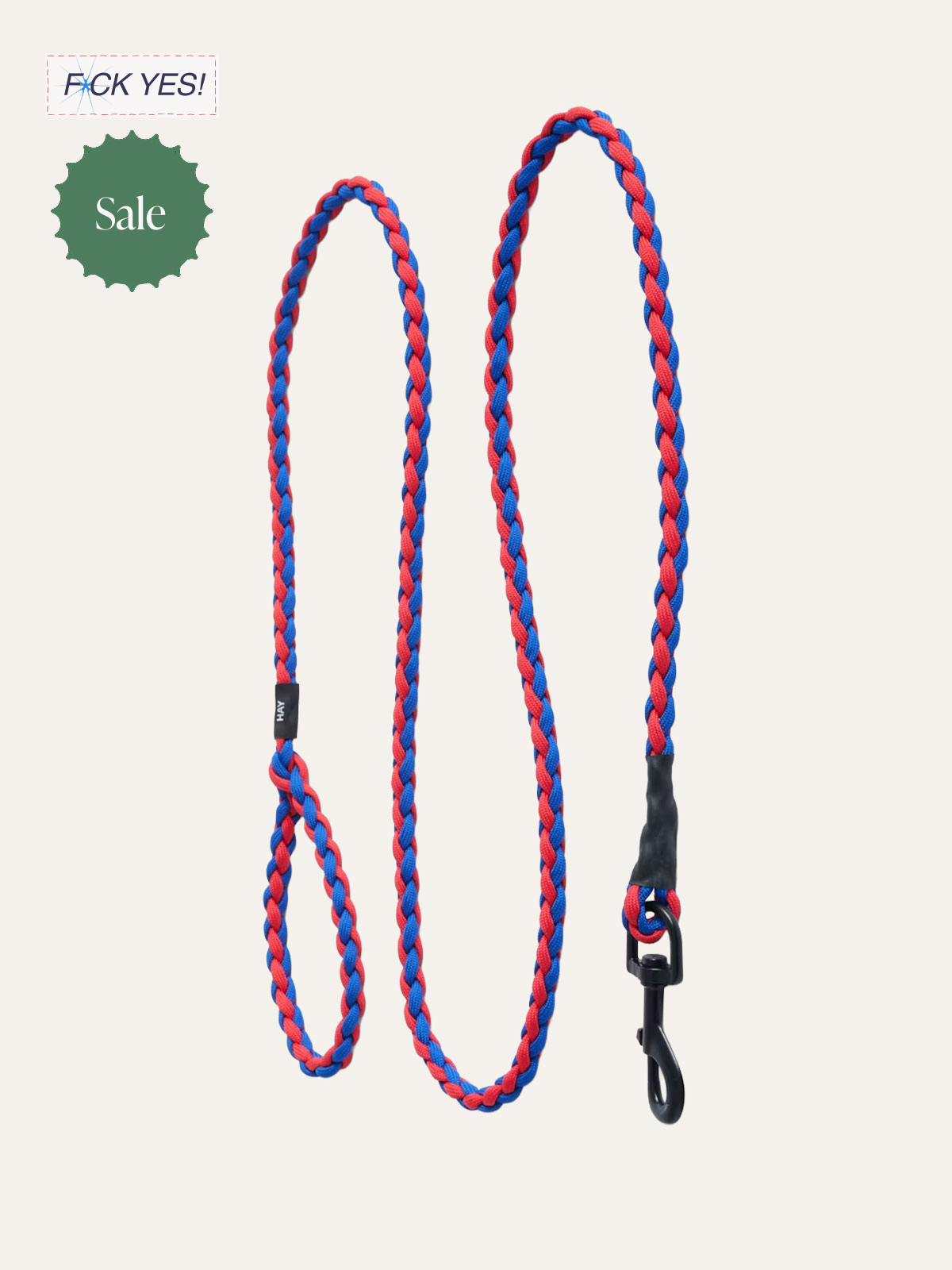 Colorful braided dog leash with black clip and label, featuring red and blue stripes on a light background.