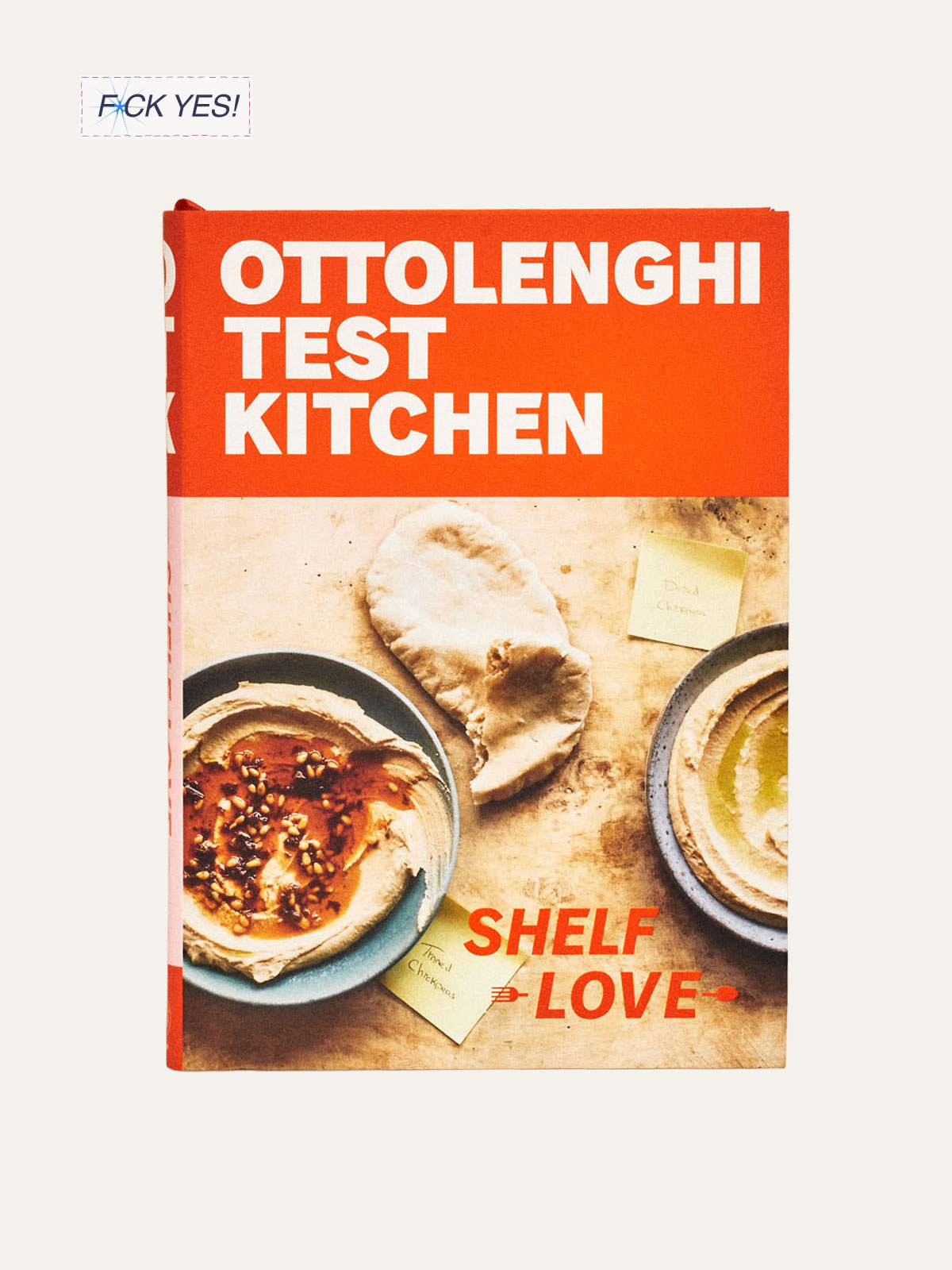 Cover of a book titled 'Ottolenghi Test Kitchen' with a photo of hummus, pita bread, and small notes on a wooden surface.