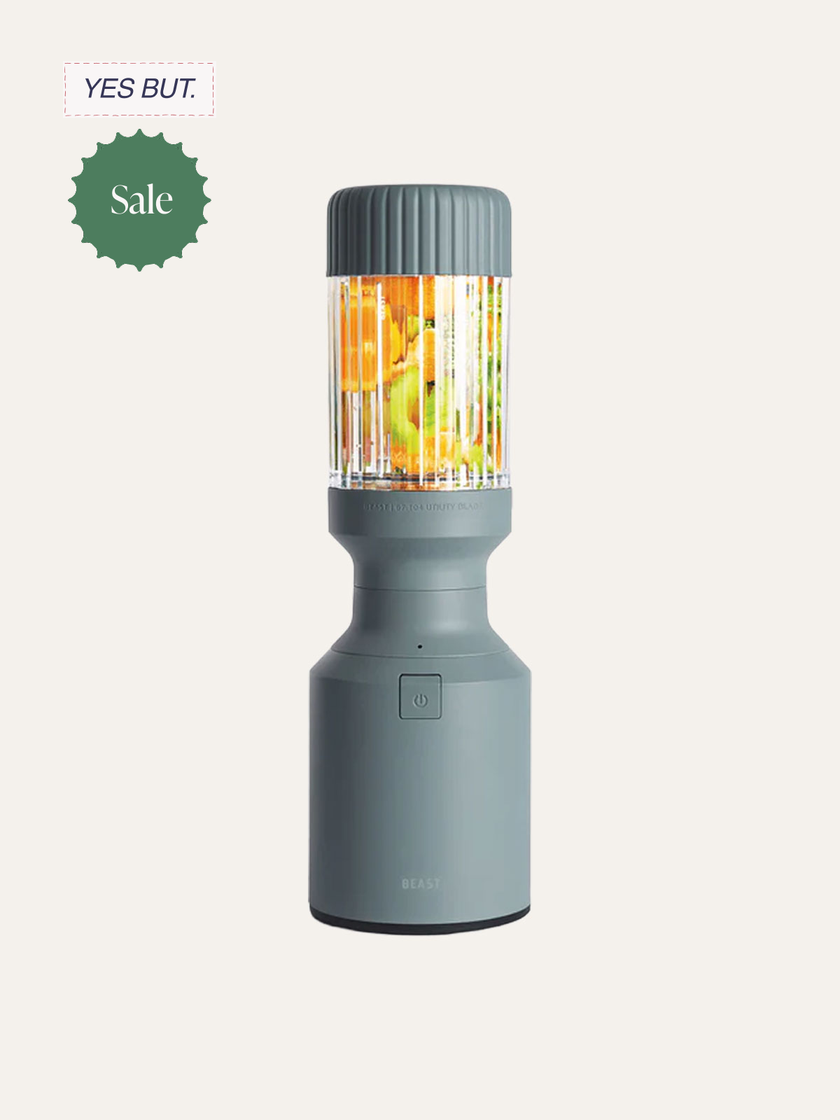 A portable blender with a grey body and a ribbed grey lid, blending colorful fruits like oranges, apples, and greens, against a light-colored background.