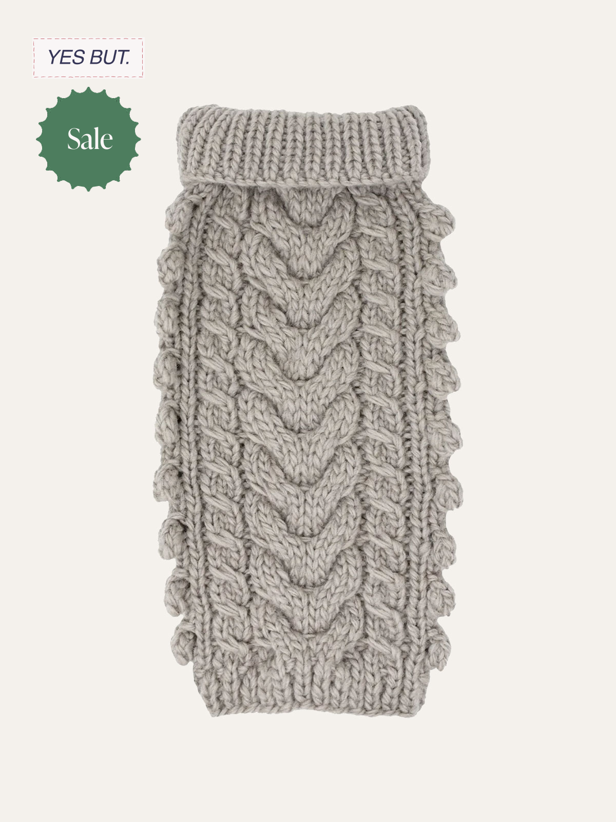 A knitted gray clothing item with a cable knit pattern and a rolled-up collar.