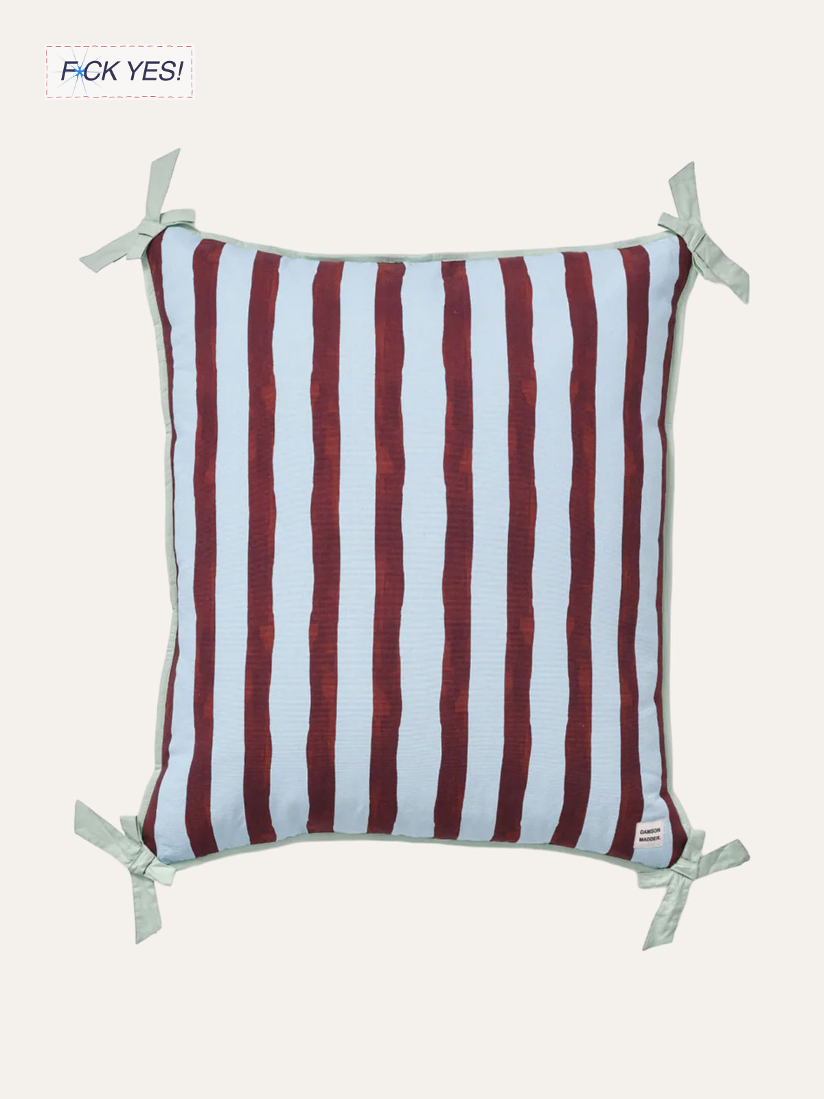 Square pillow with vertical red and white stripes and tied corners on a beige background.