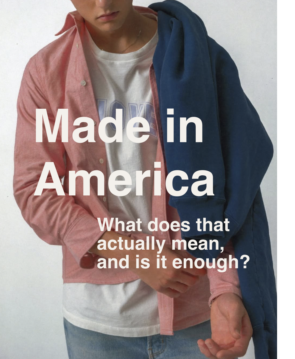 Person wearing a pink shirt over a white T-shirt with text overlay reading 'Made in America', holding a blue jacket. The text asks, 'What does that actually mean, and is it enough?'