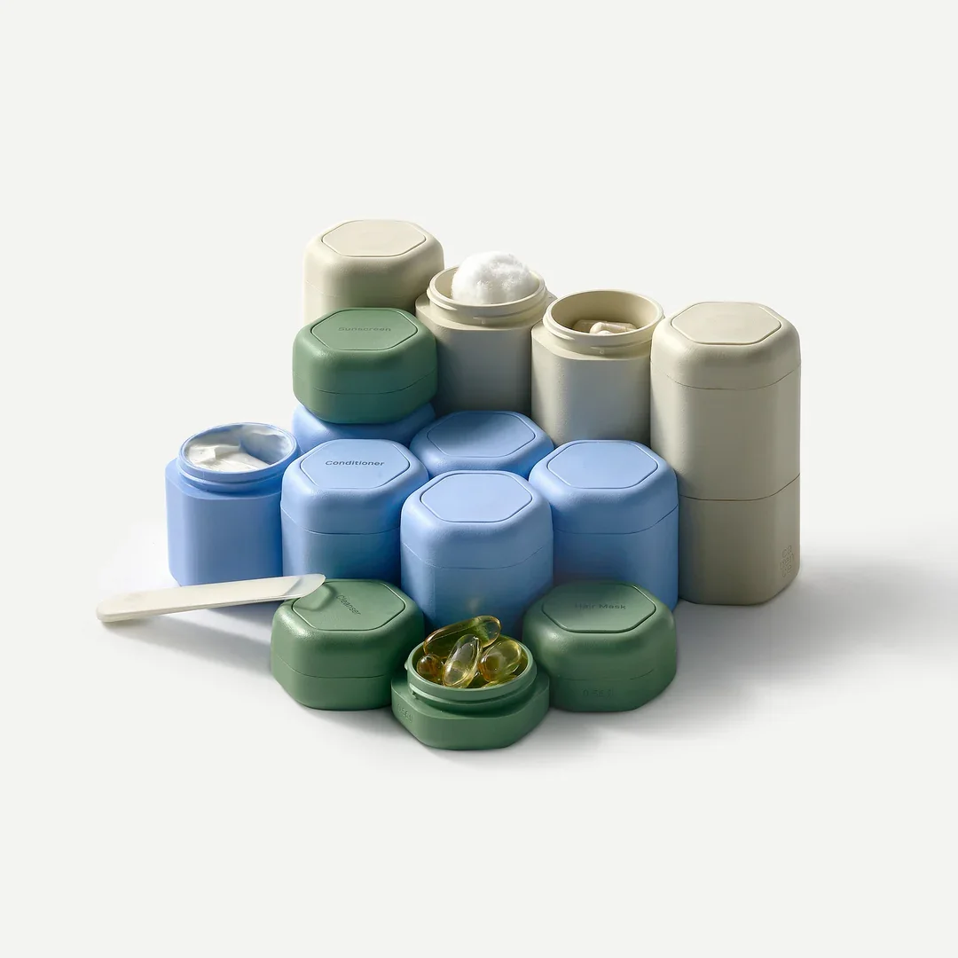 Assorted skincare and beauty product containers in pastel green, blue, and cream colors, arranged on a white background.