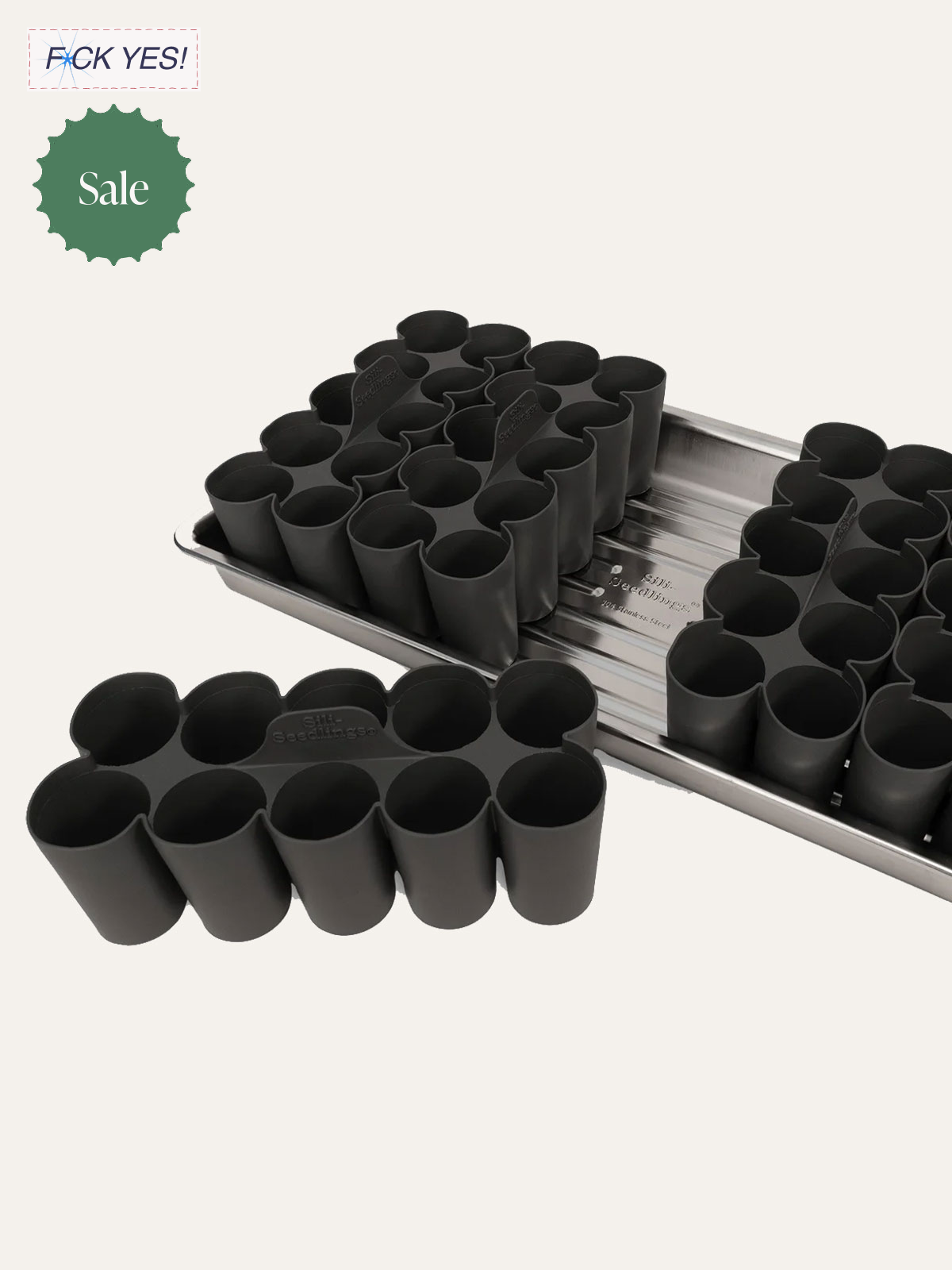 Black silicone seedling cups arranged on a metal seed tray, used for starting plants from seeds.