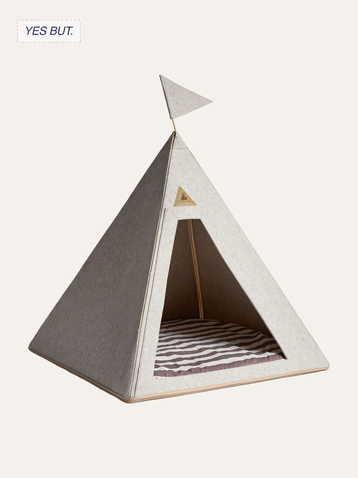 A beige fabric pet teepee with an open front, striped fabric floor, and a small triangular logo patch on the front.