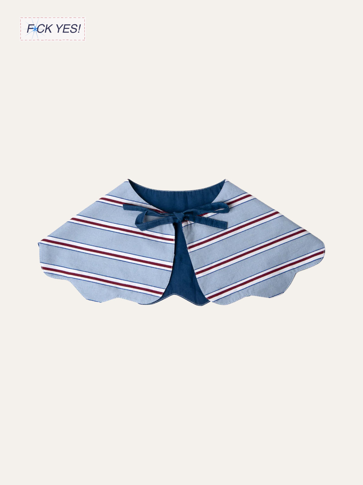 A children's cape with a striped fabric pattern in blue, white, and red, and a bow at the front.