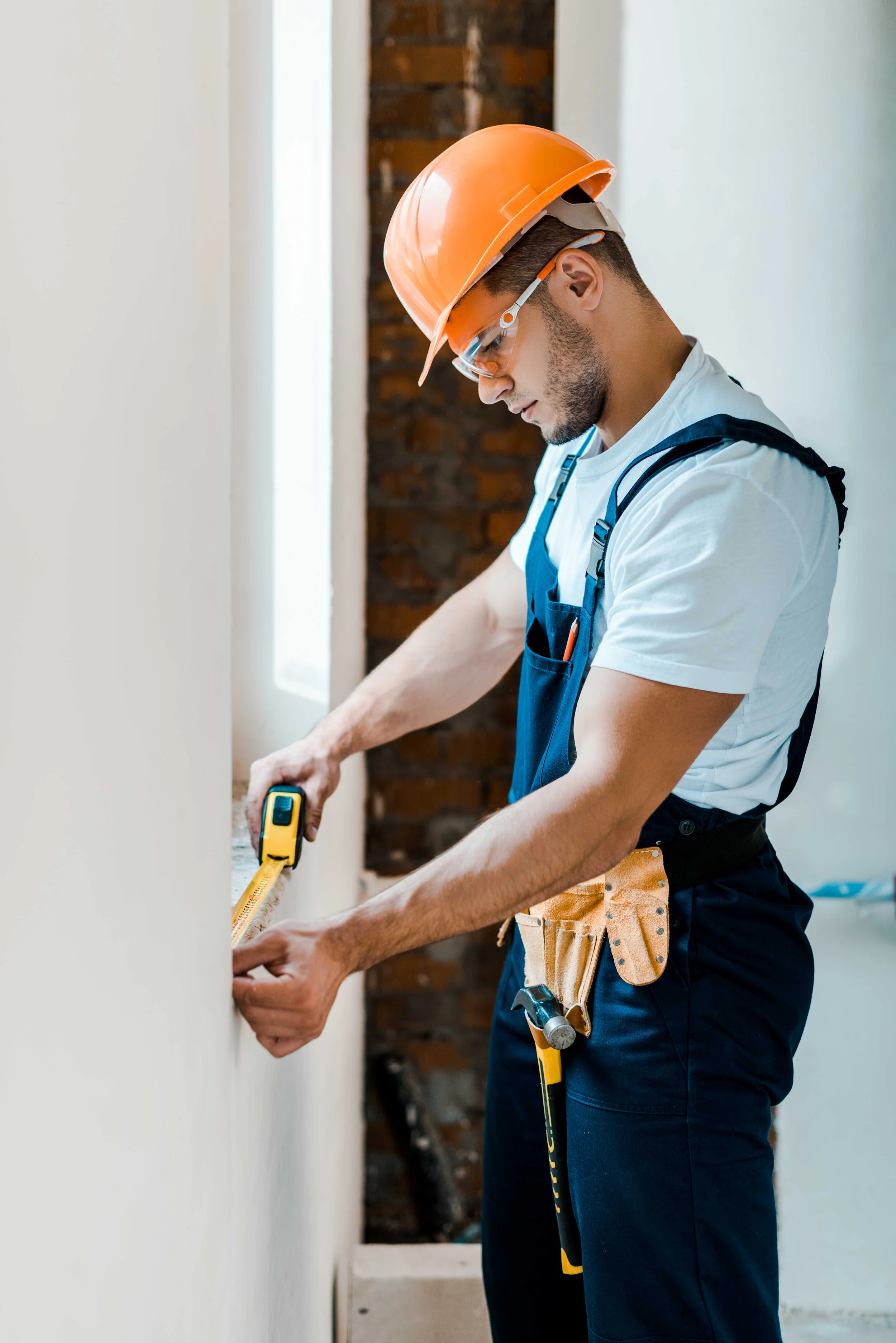 Contractor measuring a wall. Photo from Depositphotos.com
