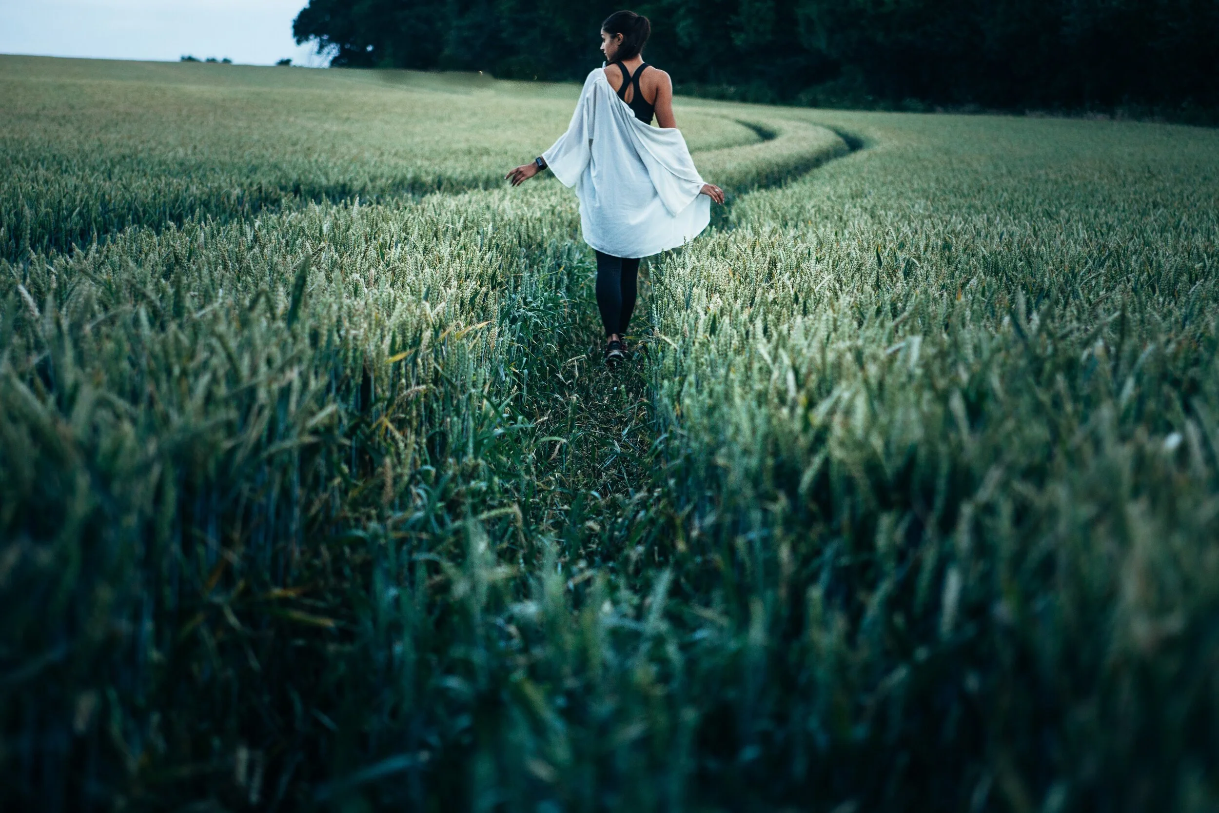 woman walking through wheat field.jpg