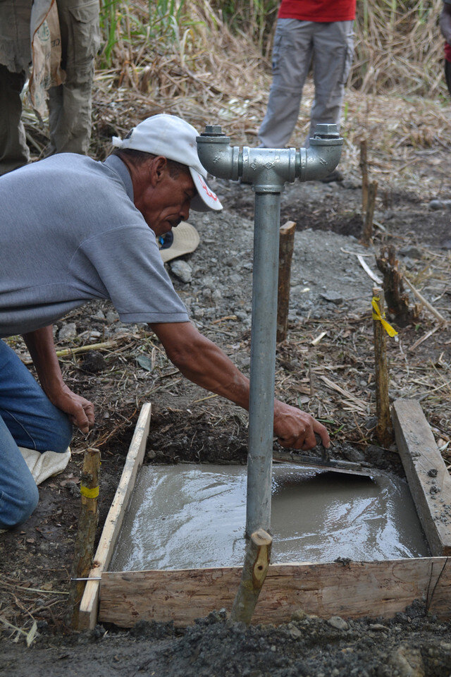 Dionisio puts the finishing touches on the pipe bridge foundation for Los Oreros.