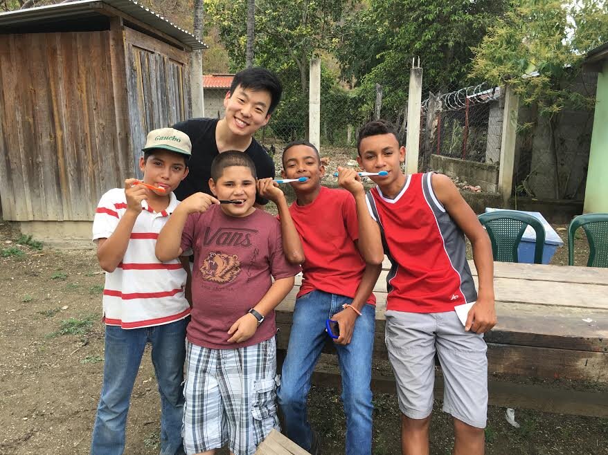 Four Fuerza boys posing with their toothbrushes after teaching families in their community about oral health.