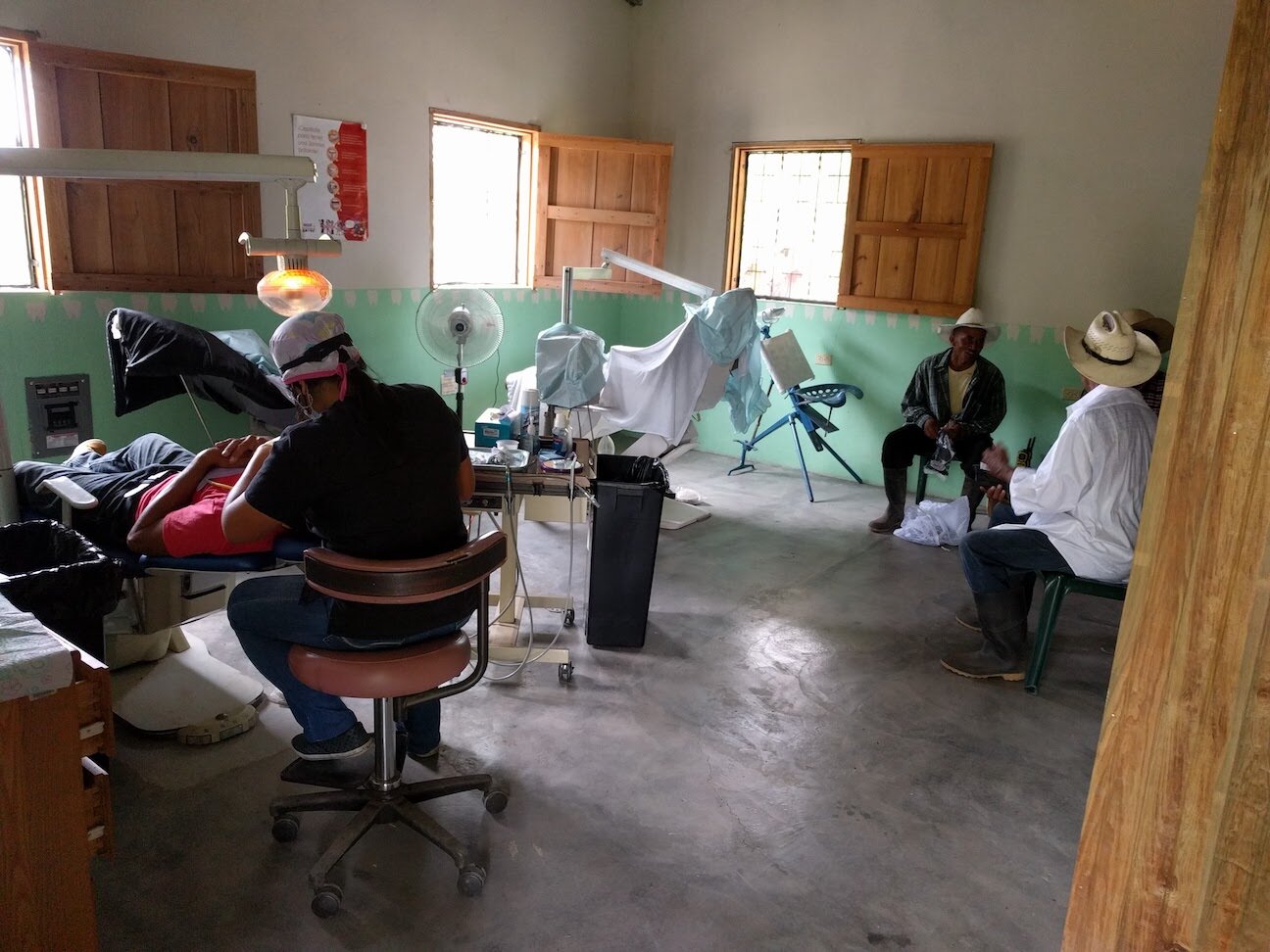 Men sit waiting to be screened at the El Rosario dental clinic.