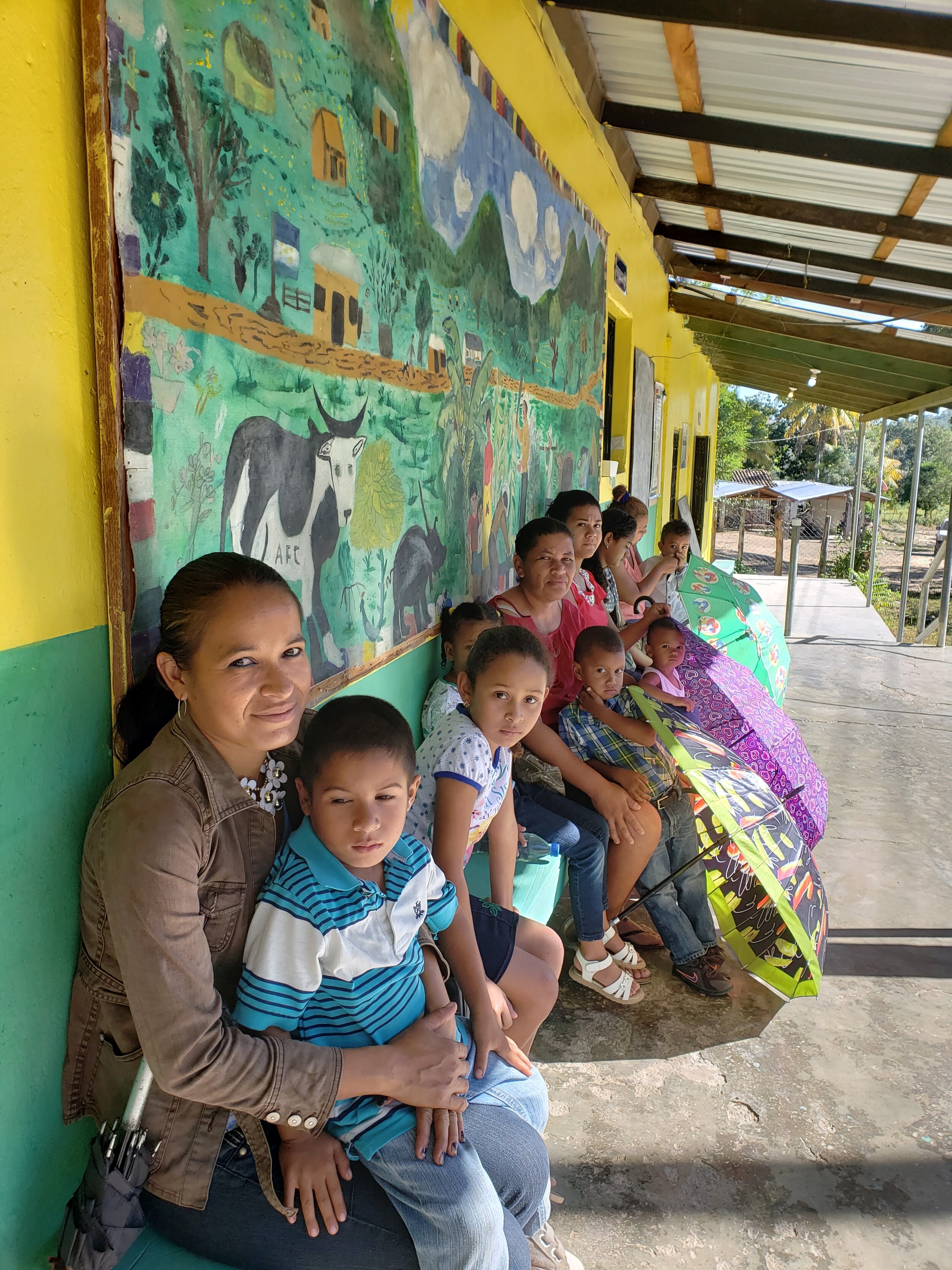 Young families wait outside the clinic for comprehensive pediatric screening including nutrition, vision, hearing, physical exam and dental evaluations.