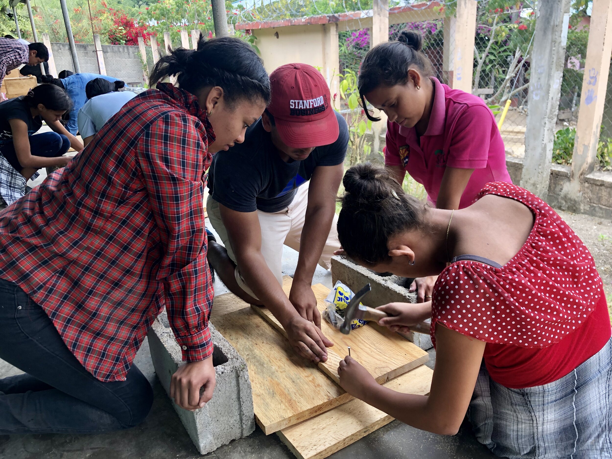 Students learn proper hammering techniques as they assemble a panel for one of the 78 chemical storage safety boxes they constructed.