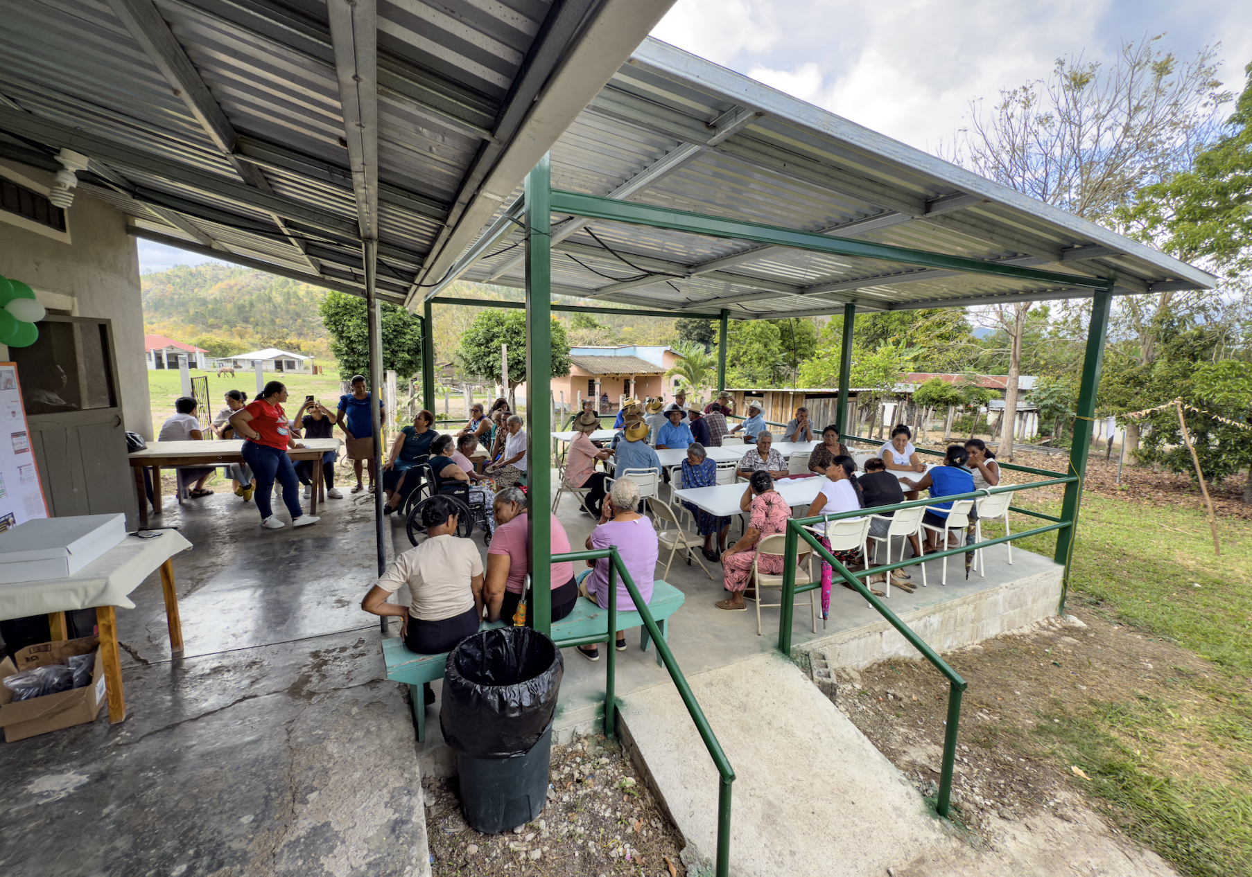 In 2026, we built this handicap accessible patio for community meetings. The sturdy chairs have arms and stack, the tables can be reconfigured, and the natural air conditioning of a gentle breeze under a broad roof make it a pleasant place for up 60 