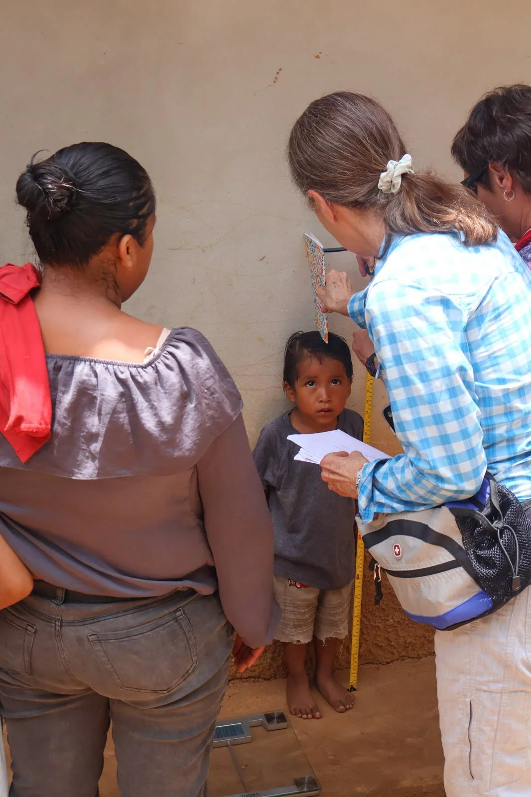 Whenever possible, we collect data and assess effectiveness of our programs. Here, Linda Kennedy and Sue Burgo are measuring growth of a toddler in the Feeding Babies & Mothers program. 