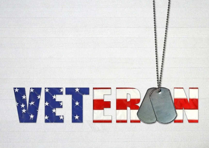 The word 'VETERAN' with an American flag design, featuring stars and stripes. A set of military dog tags hangs over the text.