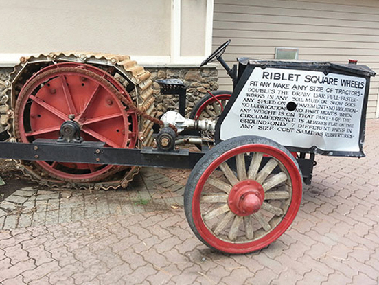 a photograph of a historical tractor that features a unique square-wheel