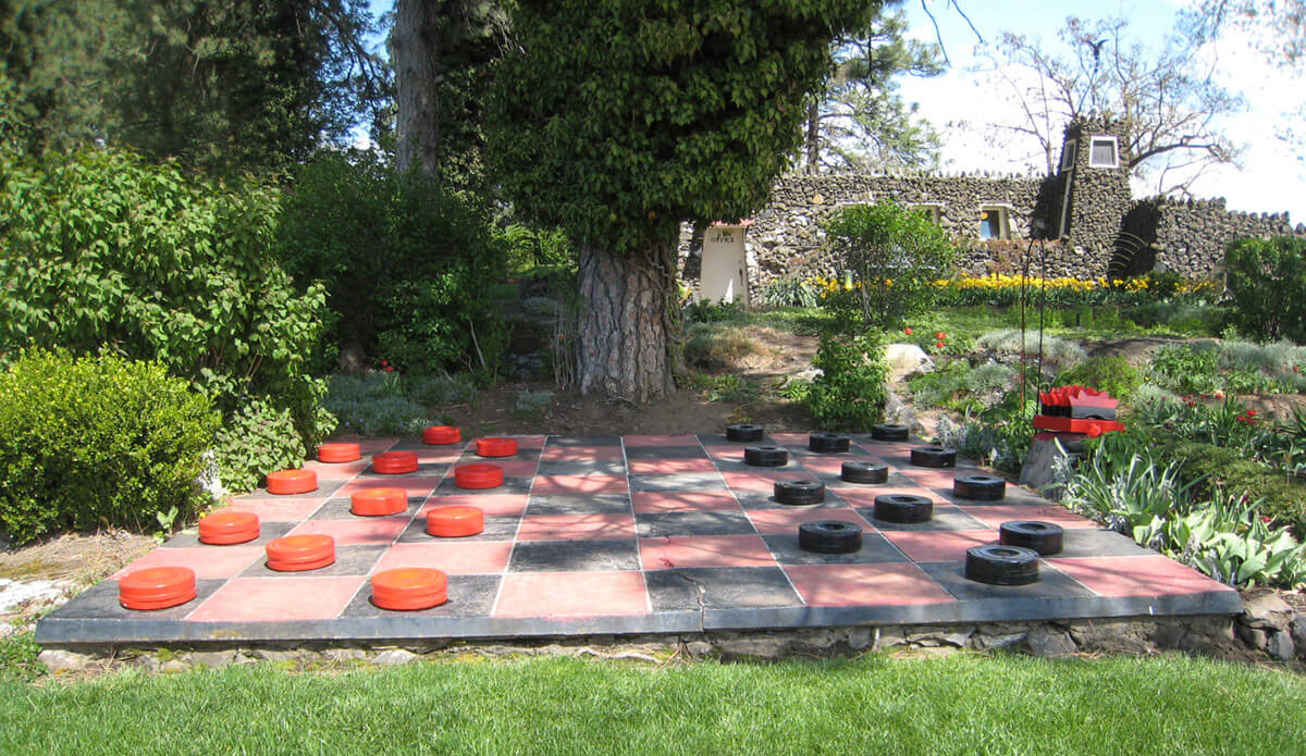 a present day photo of the life-size checkerboard with red pieces on the left and black pieces on the right
