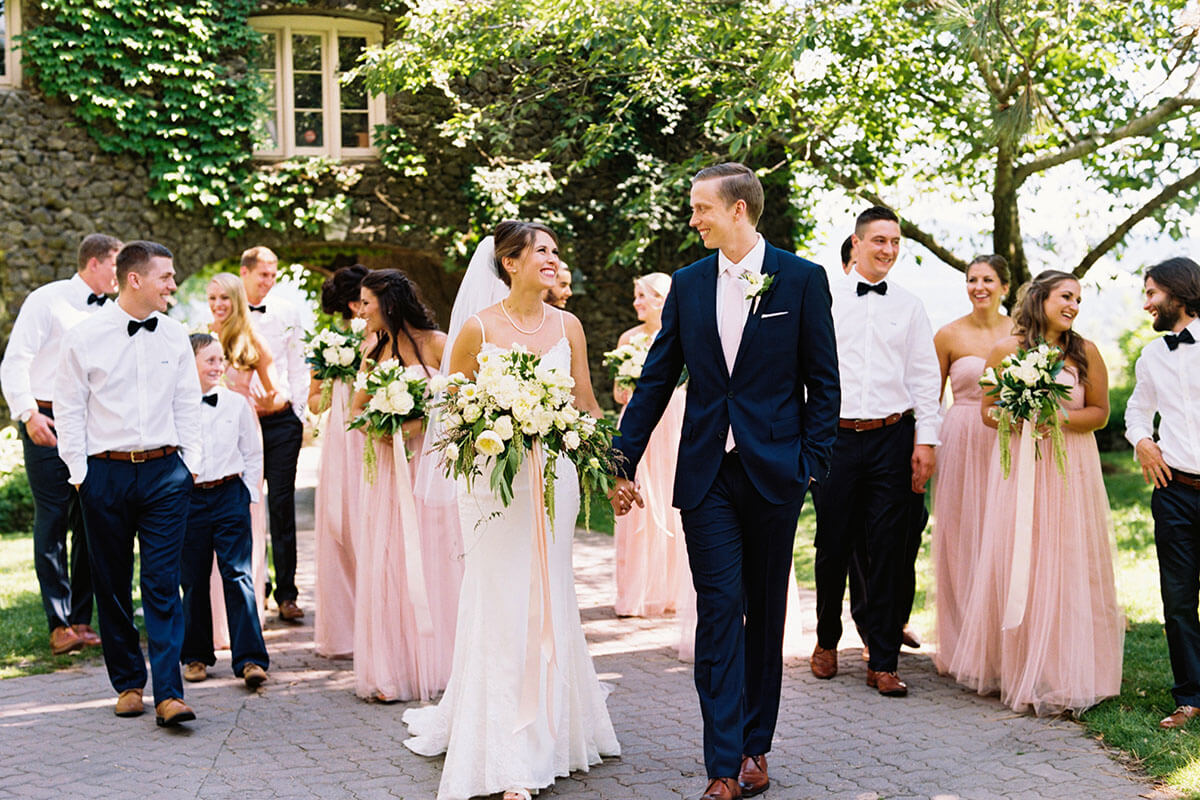 a photo of a wedding couple staring at each other and the wedding party following