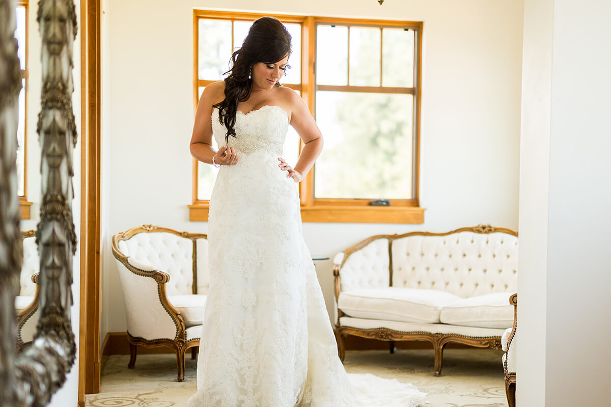 A photo of a bride getting ready in a brightly lit room that features elegant furniture