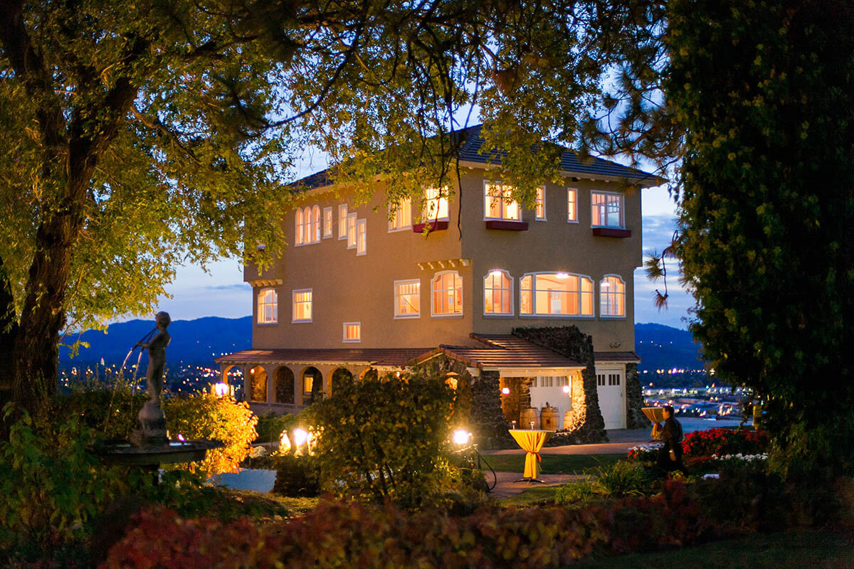 A nighttime photo of the Cliff House Estate with lights illuminating the courtyard