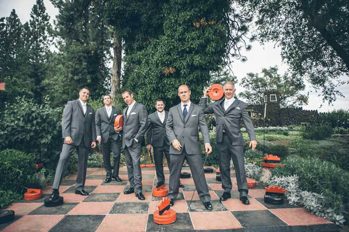 A photo of groomsmen on the life-size checkerboard 
