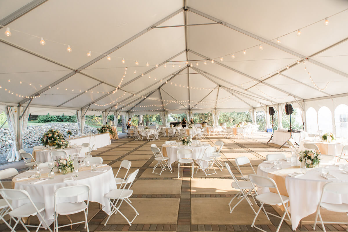 a photo of the wedding tent with lights strung to the ceiling and tables set out beneath