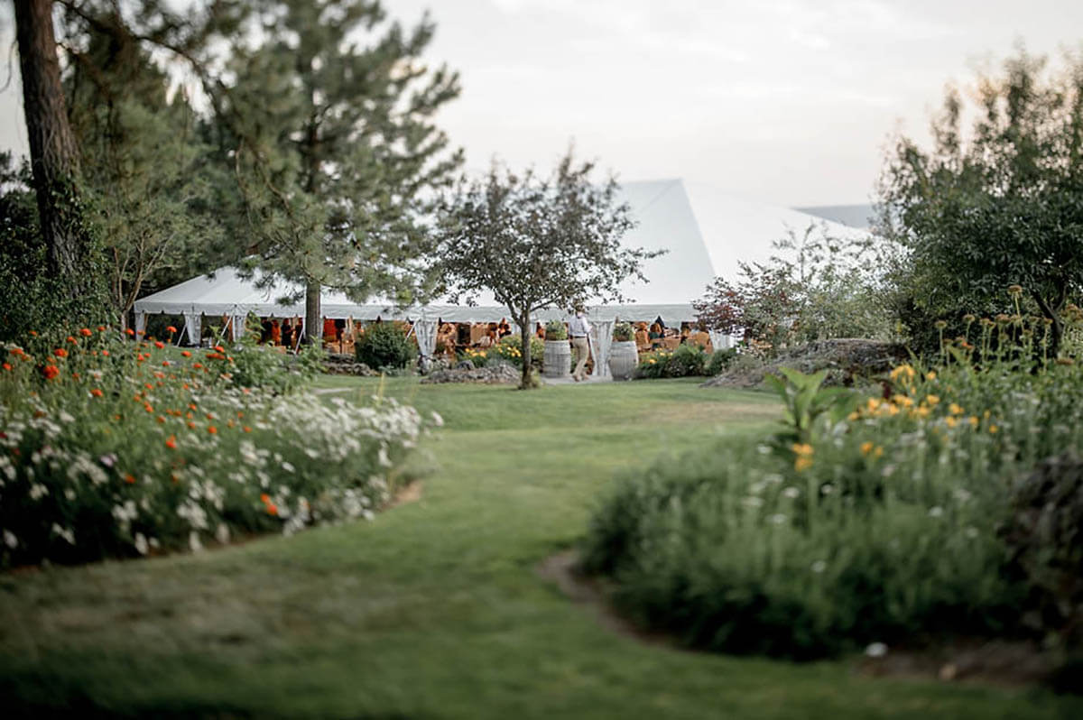 An exterior shot of the wedding tent and beautiful flowers and trees