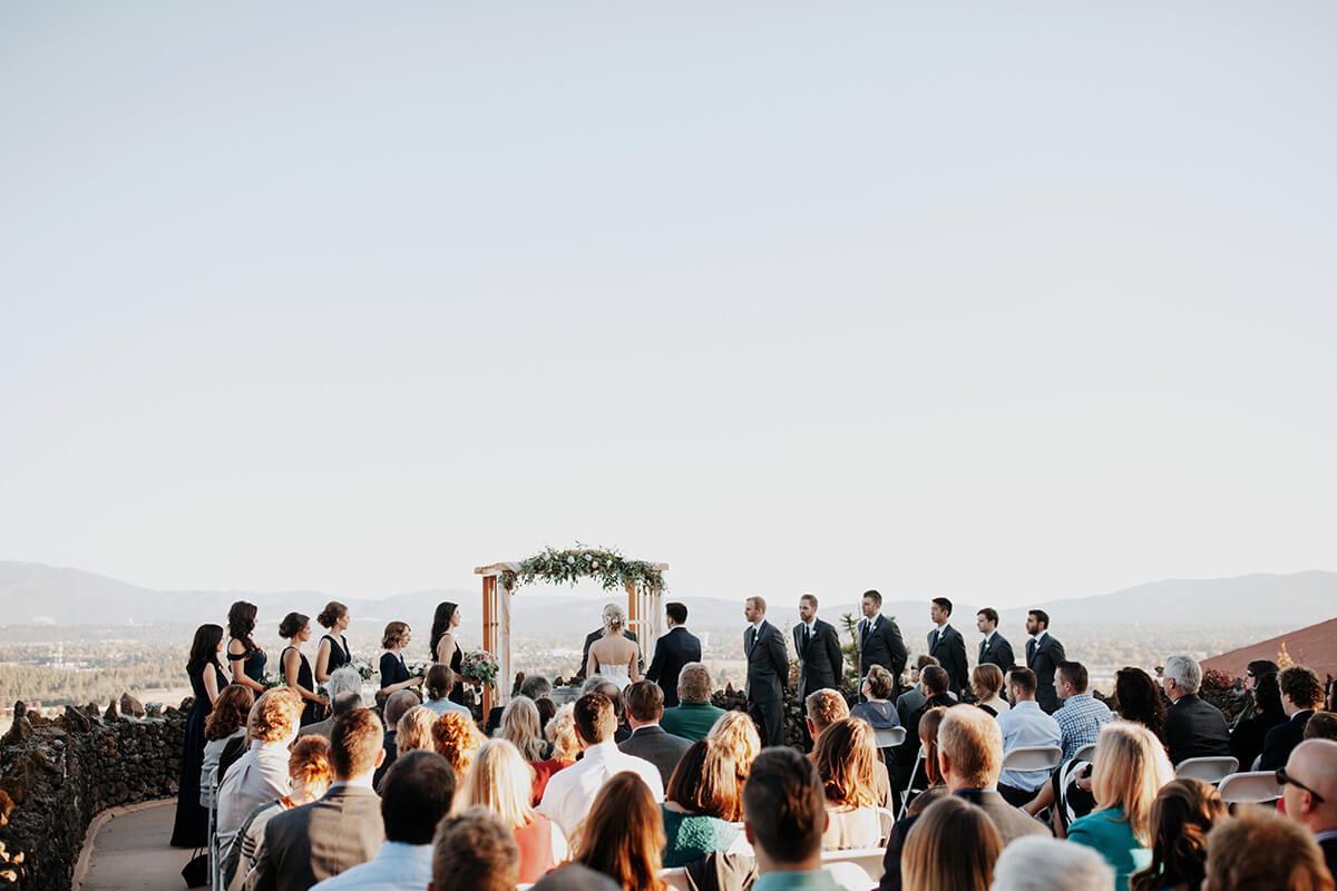 A photo of a wedding ceremony with the crowd and the ceremony on the bottom and a wide open sky partitioning the photo