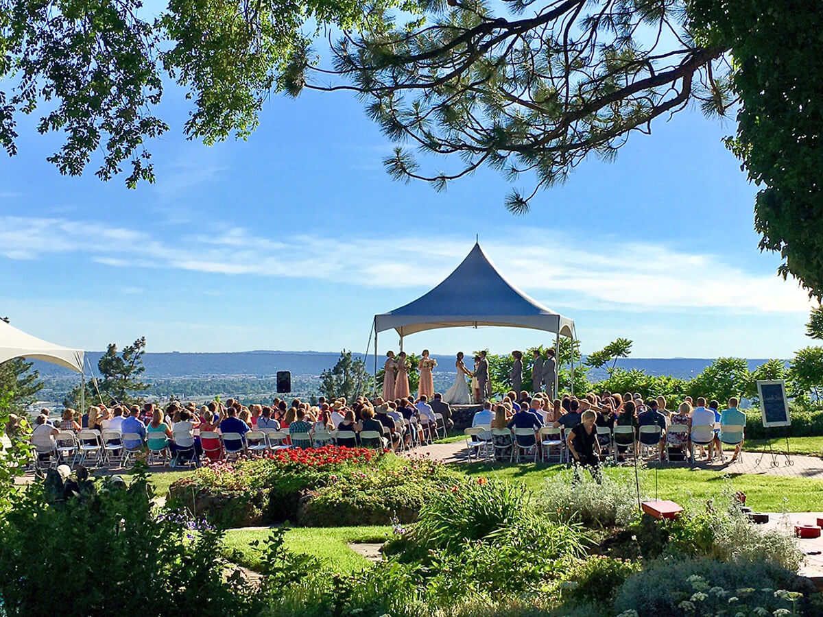 A photo of a ceremony on the Estate grounds with a clear blue sky behind the ceremony.